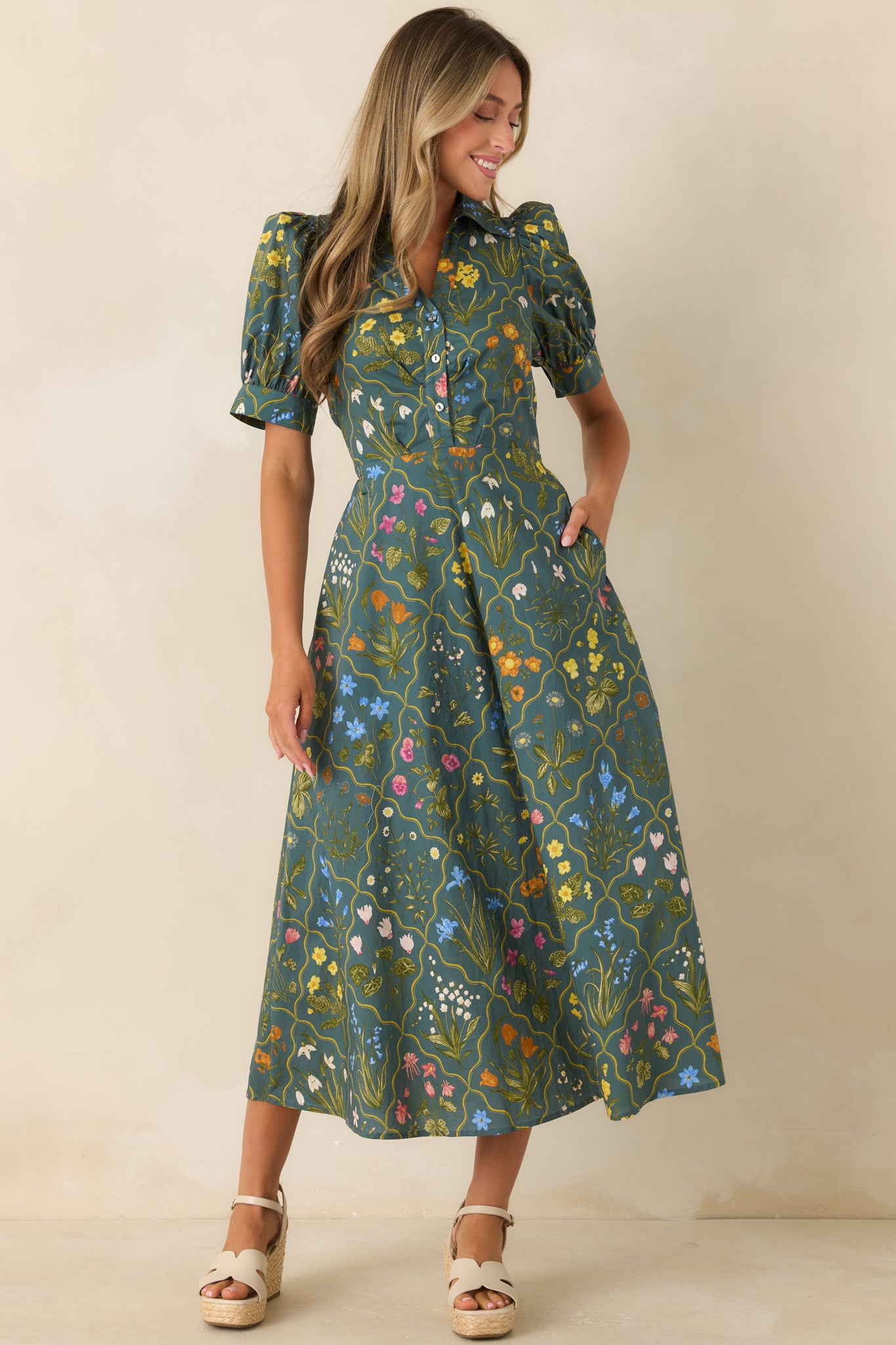 Cotton midi dress featuring a hunter green floral print, structured puff sleeves, and a flattering collared neckline.