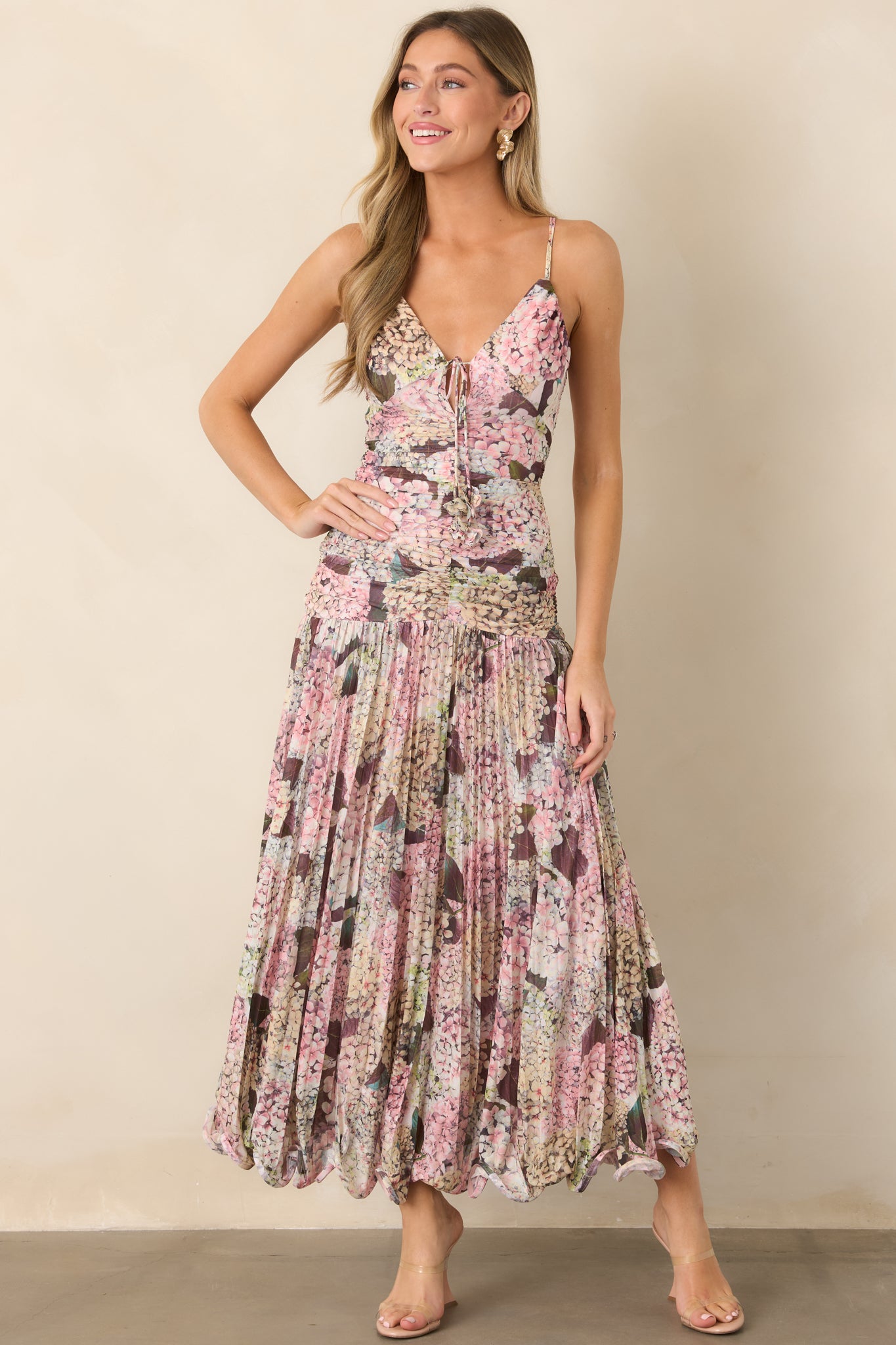 Hydrangea-inspired floral dress featuring delicate shoulder straps, a ruched bodice, softly flowing maxi skirt, and structured wavy hem.