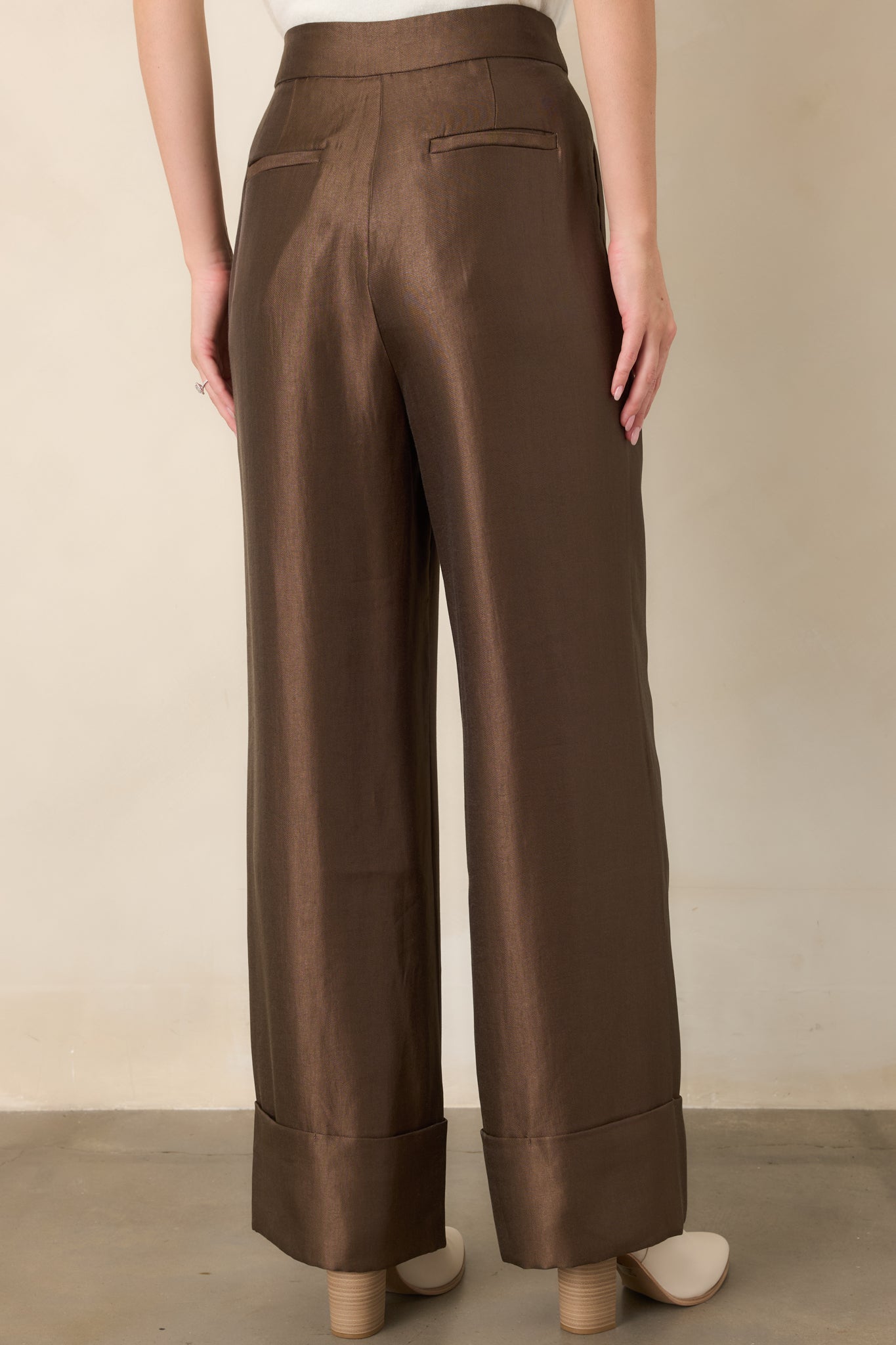 Rear view of the iced brown wide-leg pants showcasing the high-rise waist, smooth drape, faux welt pockets, and oversized cuffs.