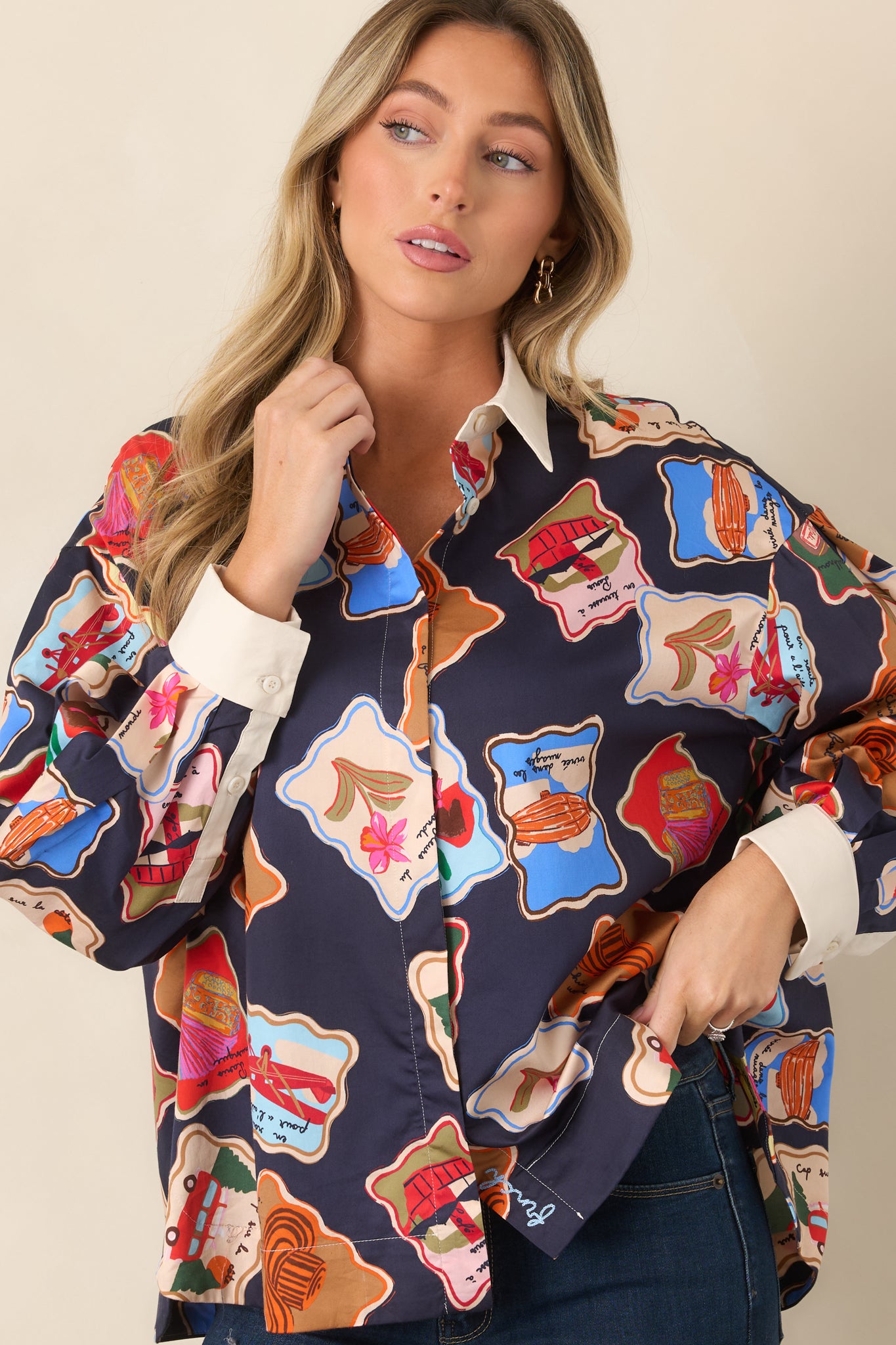 Front detail of the printed top highlighting its colorful illustrated motifs, contrasting ivory collar, and button-front closure.