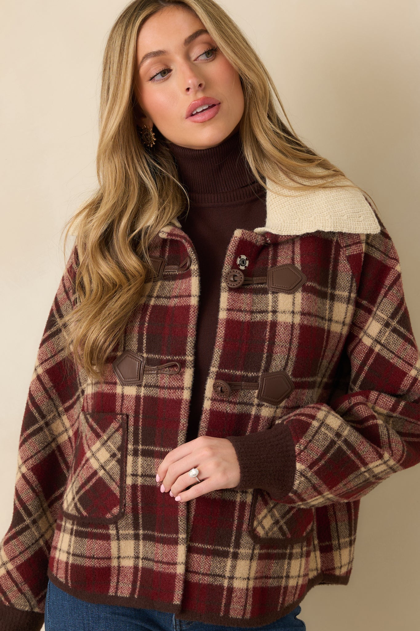 Cropped front image focusing on front button closure and plaid pattern alignment.