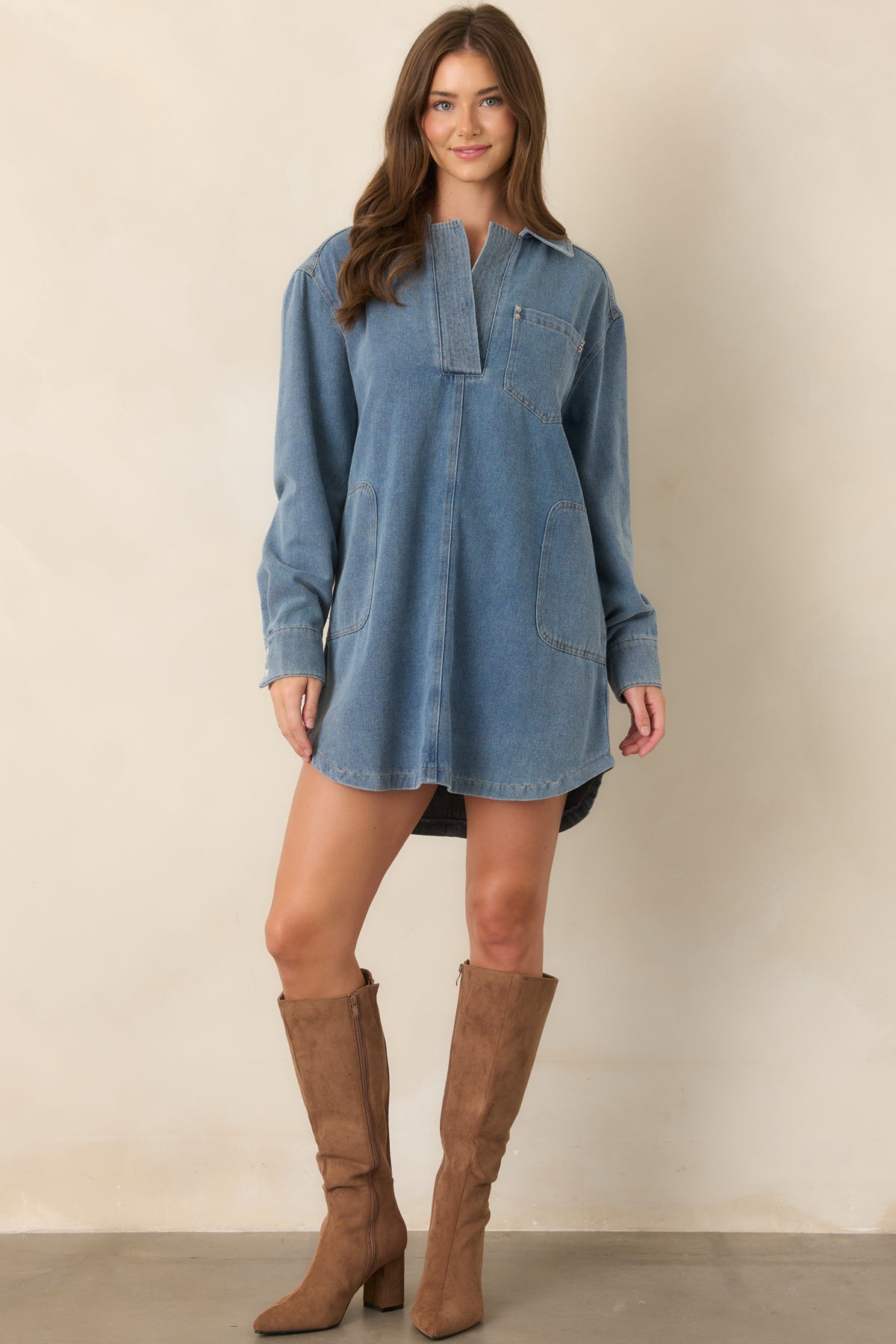 Medium indigo mini dress showcasing its classic collar, partial button closure, cuffed long sleeves, relaxed shape, and practical front patch pockets.