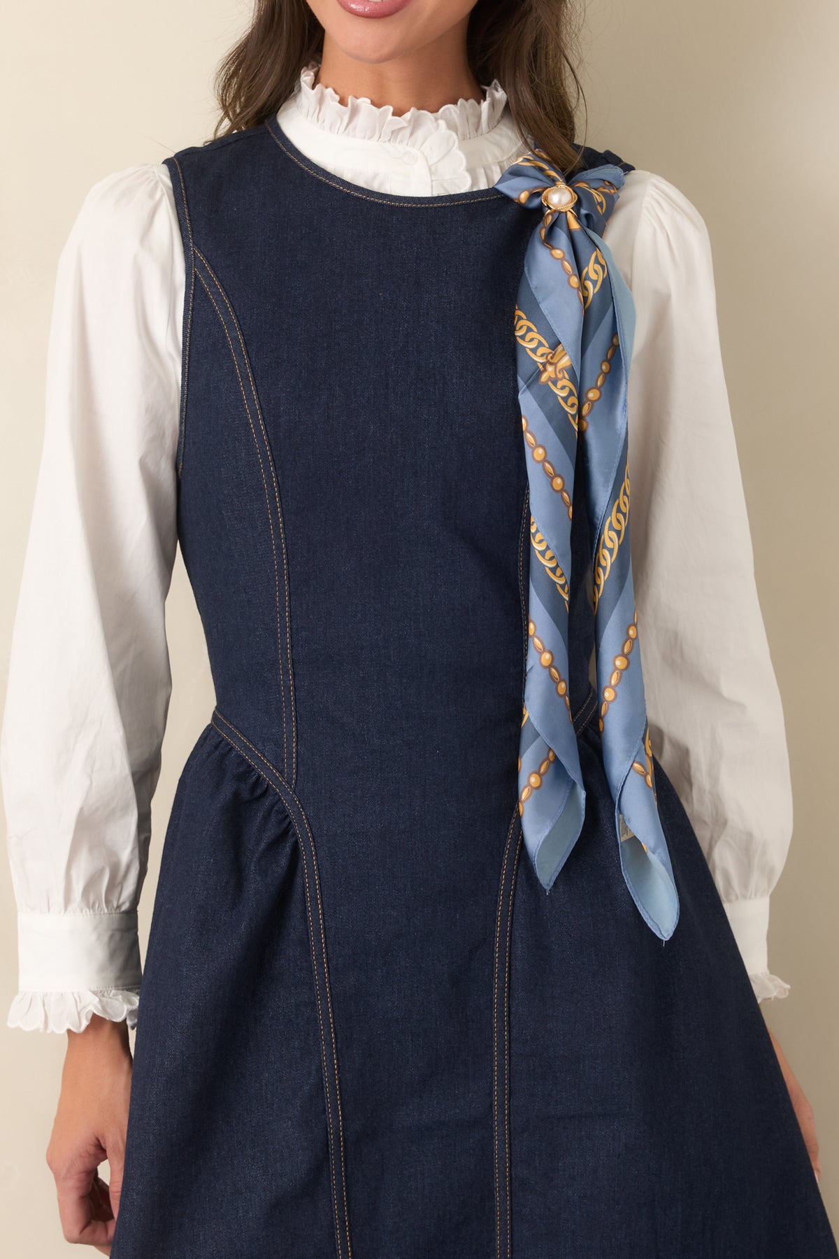 Close-up of the indigo denim, contrast stitching, curved bodice seams, and wide stitched hem.