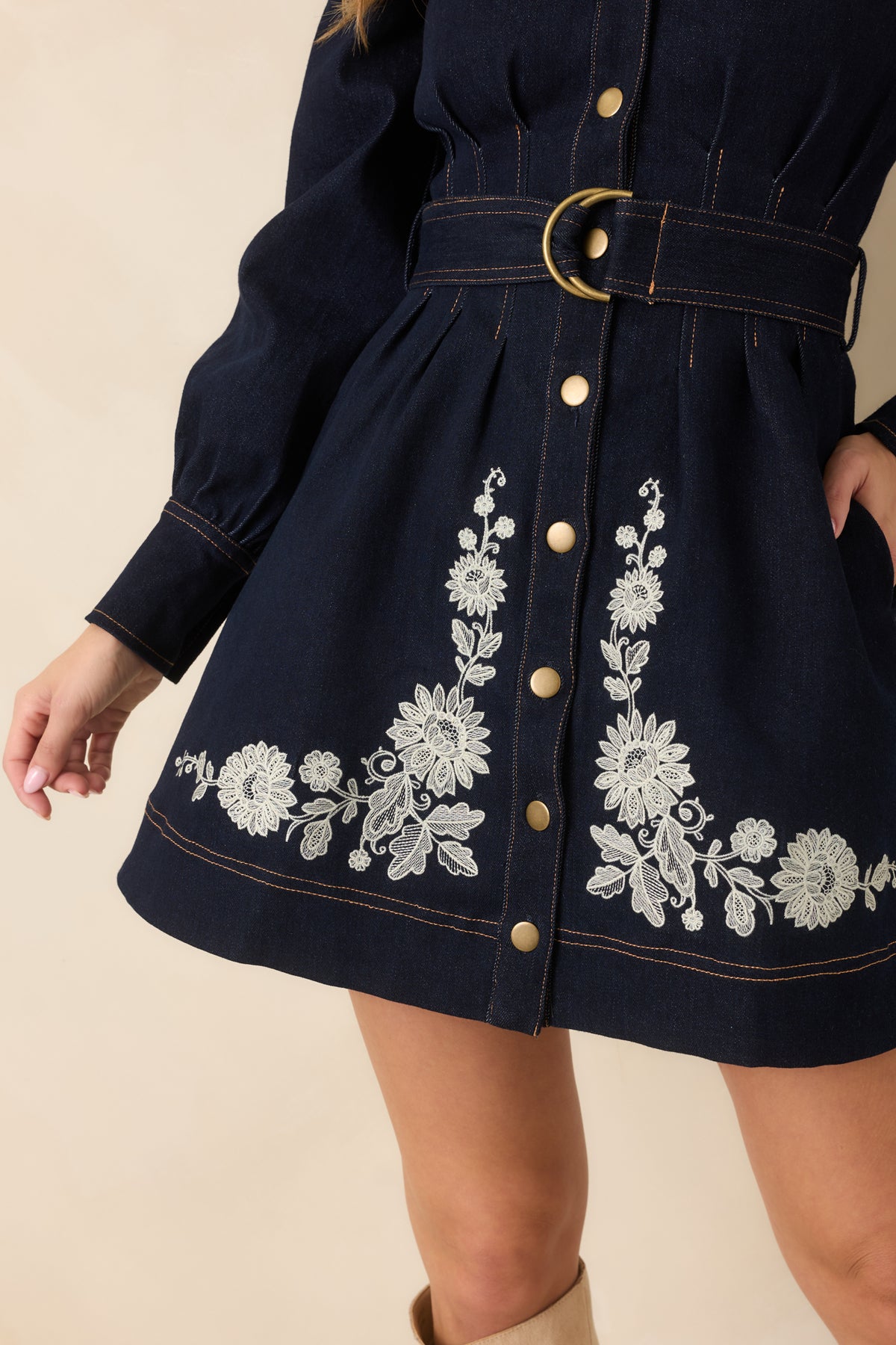 Indigo denim dress highlighting the floral print, contrast stitching, and pleated detailing across the skirt.