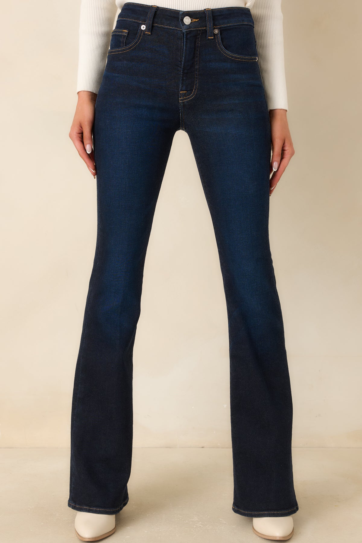 Subtle fading across the indigo denim highlights the fitted thighs and gradual flare toward the hems.