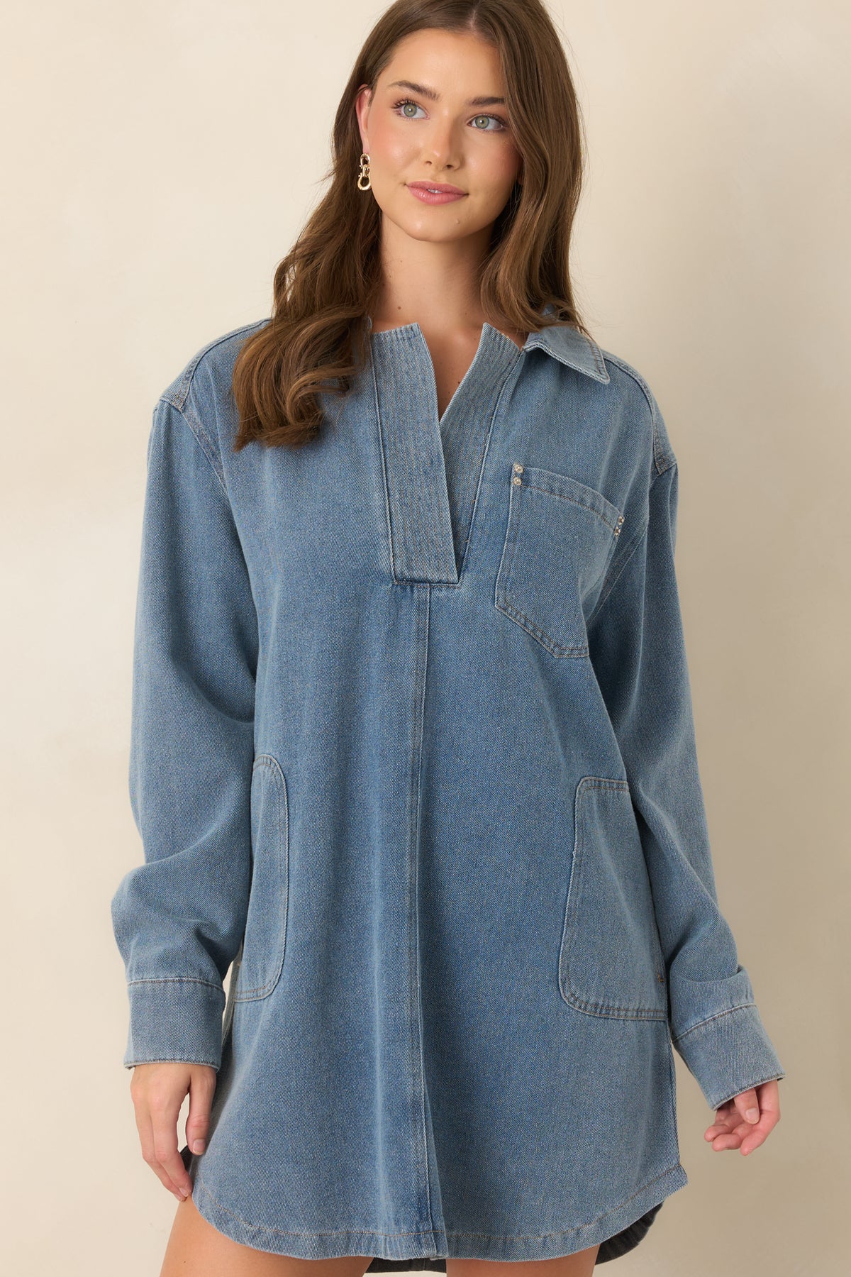 Indigo denim mini dress featuring a front patch pocket and clean button placket against its structured cotton denim fabric.