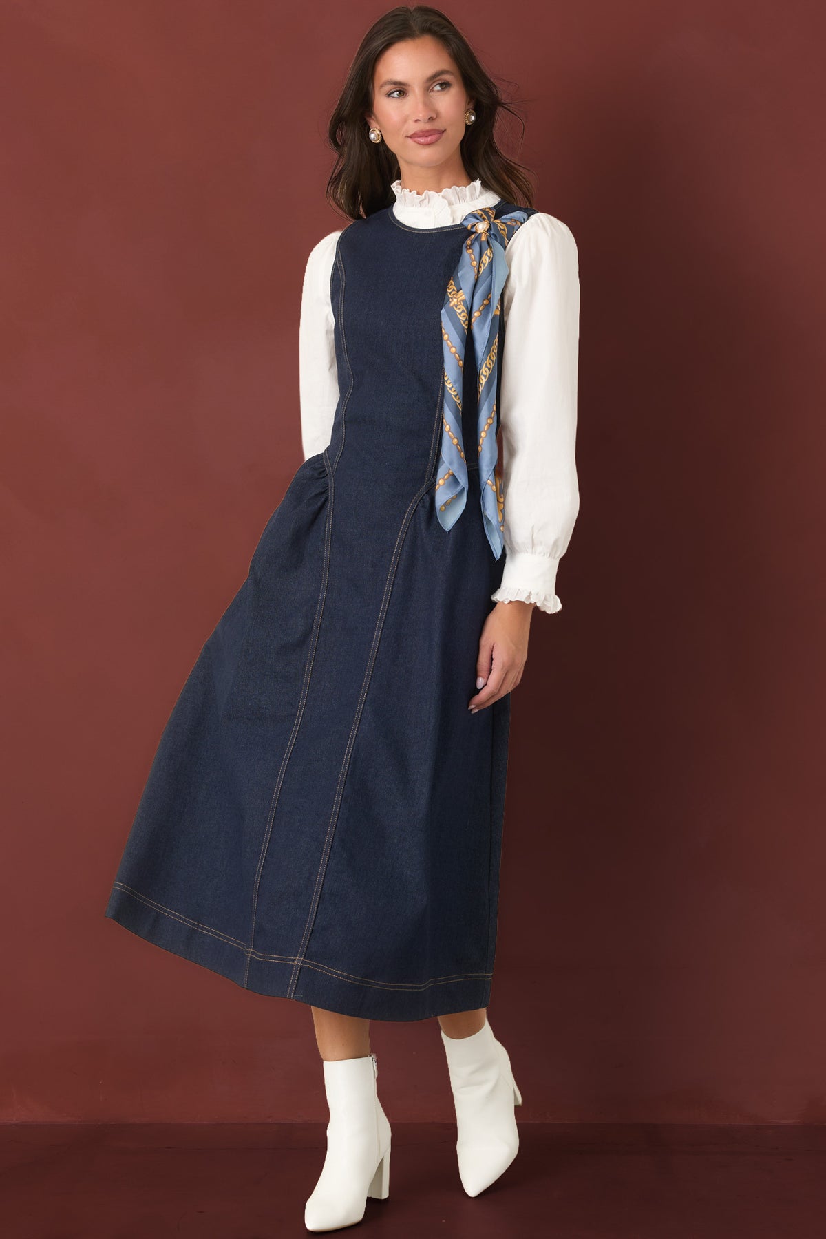 Full body of the indigo denim, contrast stitching, curved bodice seams, and wide stitched hem.
