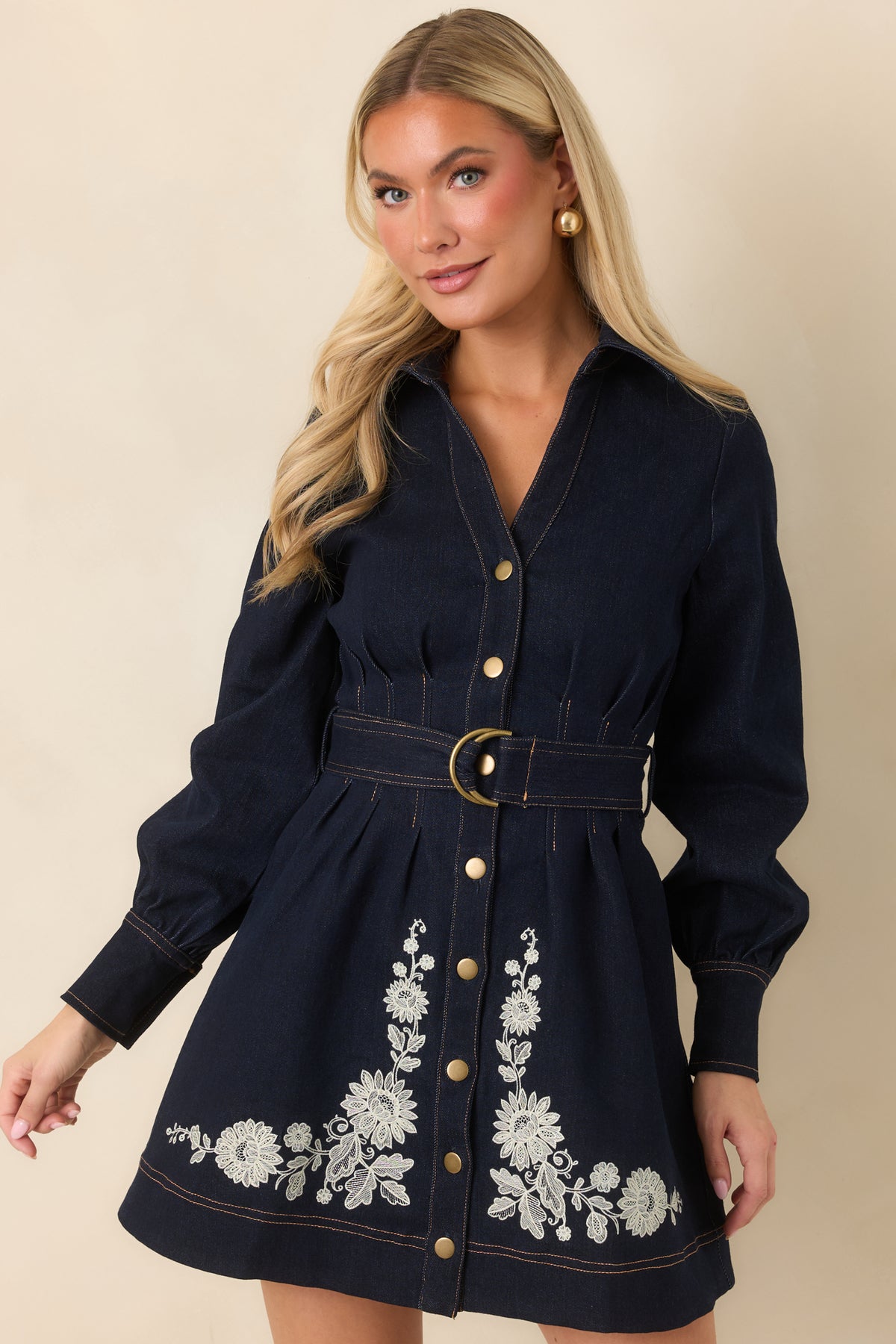  Indigo mini dress showcasing long sleeves finished with buttoned cuffs and a gently flared skirt.