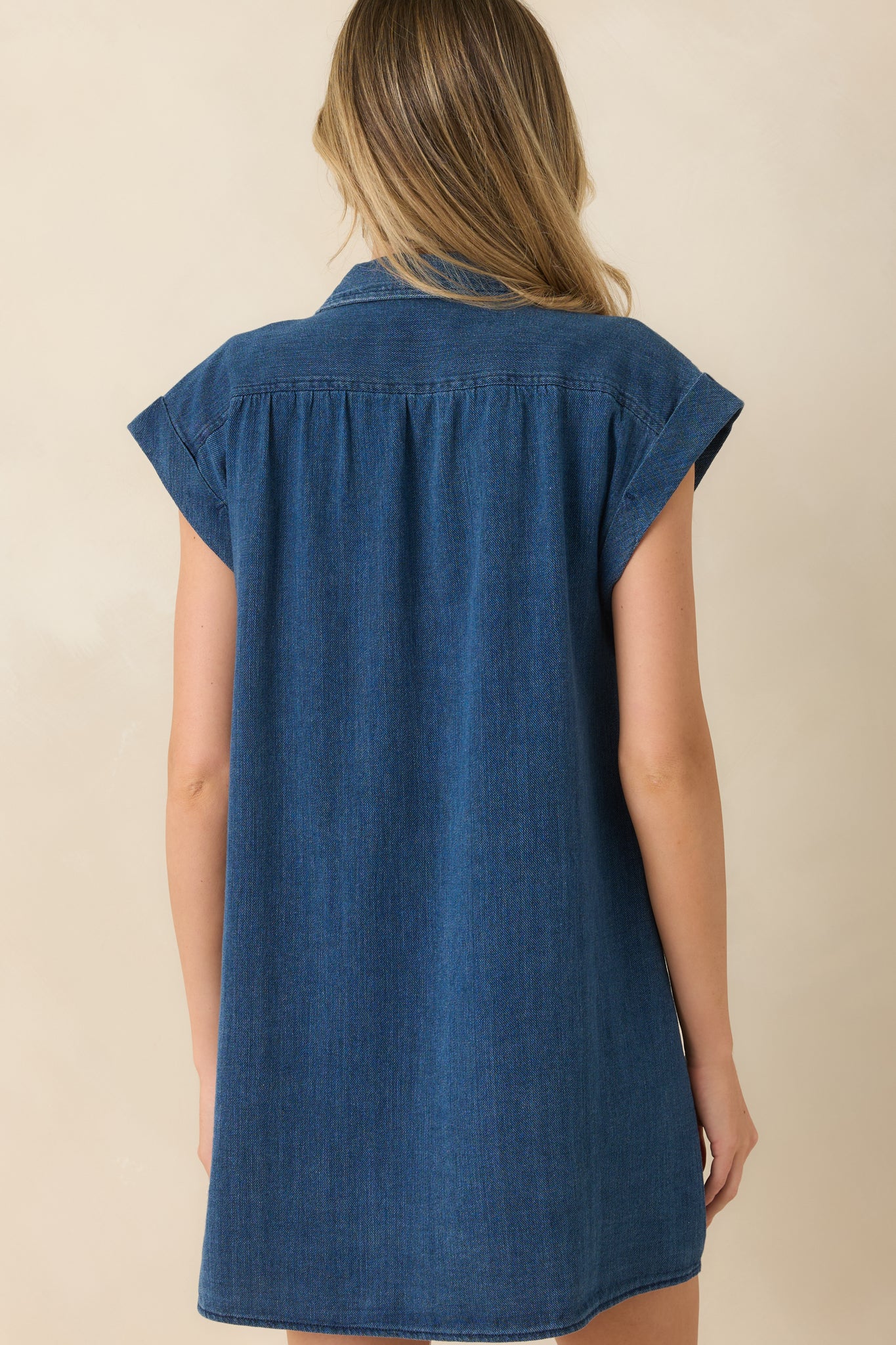 Back view of the indigo cotton shirt dress featuring a breezy silhouette and gathered shoulder detailing.