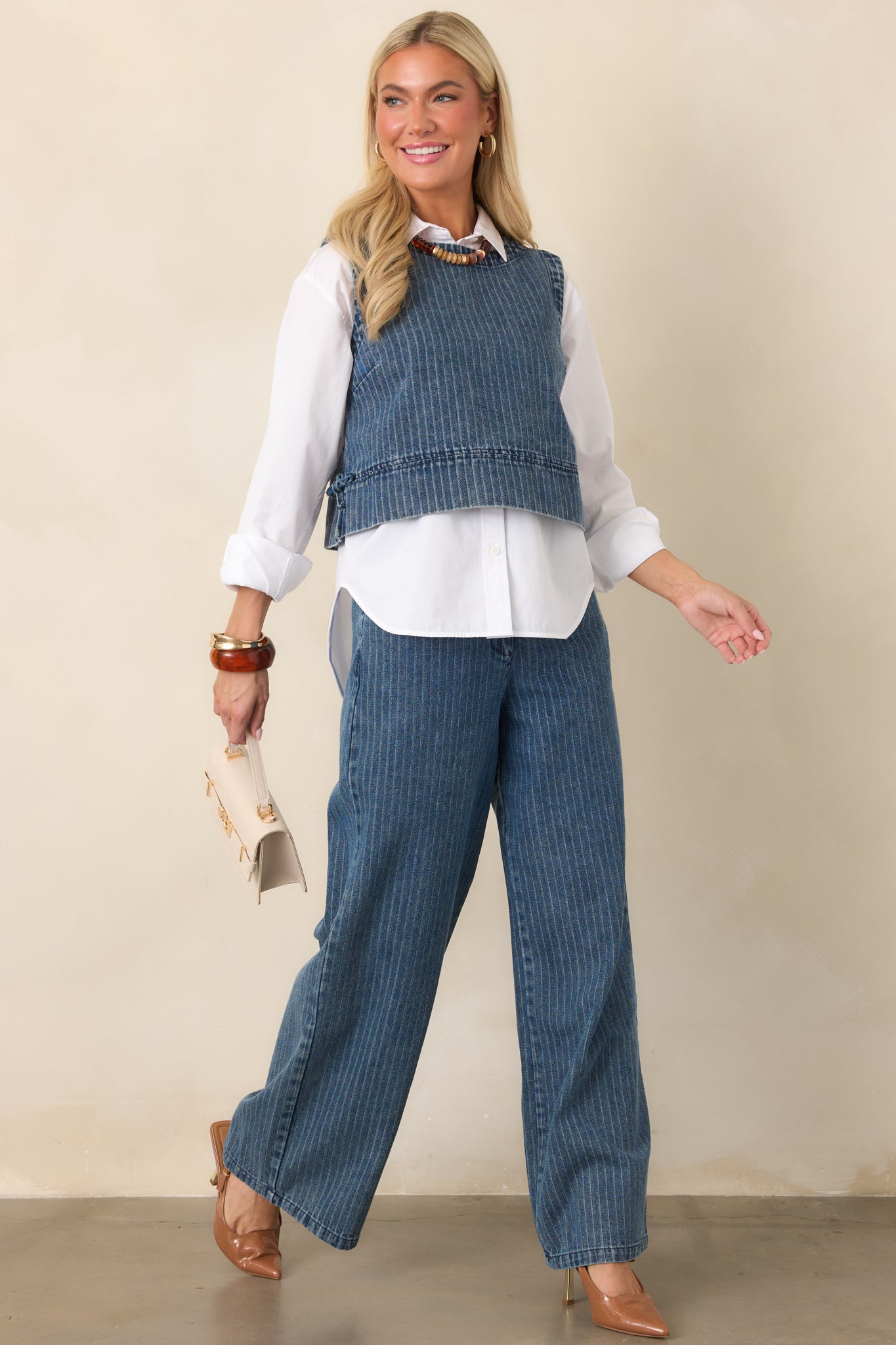 Indigo stripe crop top featuring soft cotton-blend denim, a sleeveless silhouette, rounded neckline, side tie accents, and cropped length.
