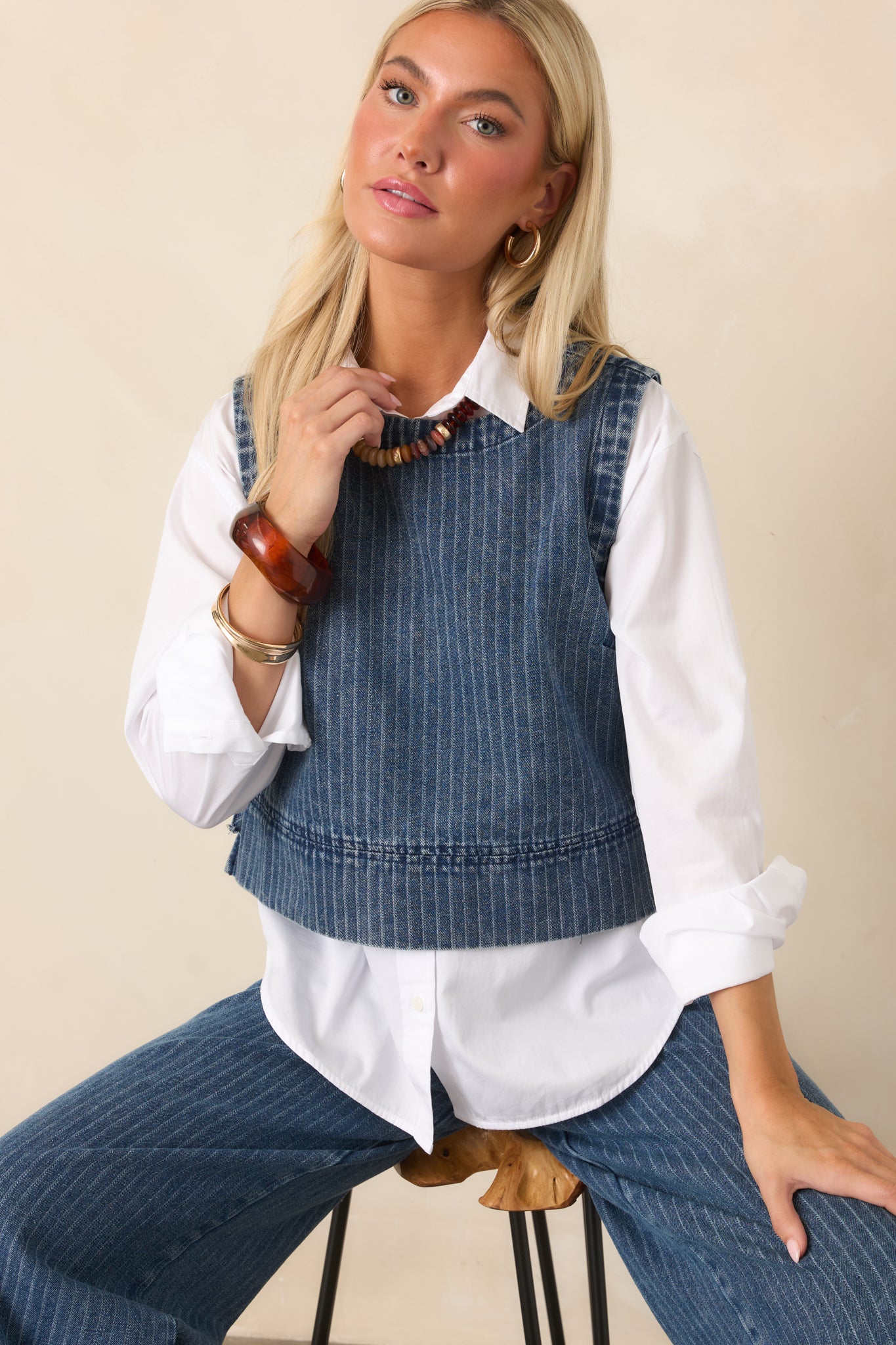 Front detail of the indigo striped crop top highlighting its rounded neckline, sleeveless construction, and soft cotton-blend denim texture.