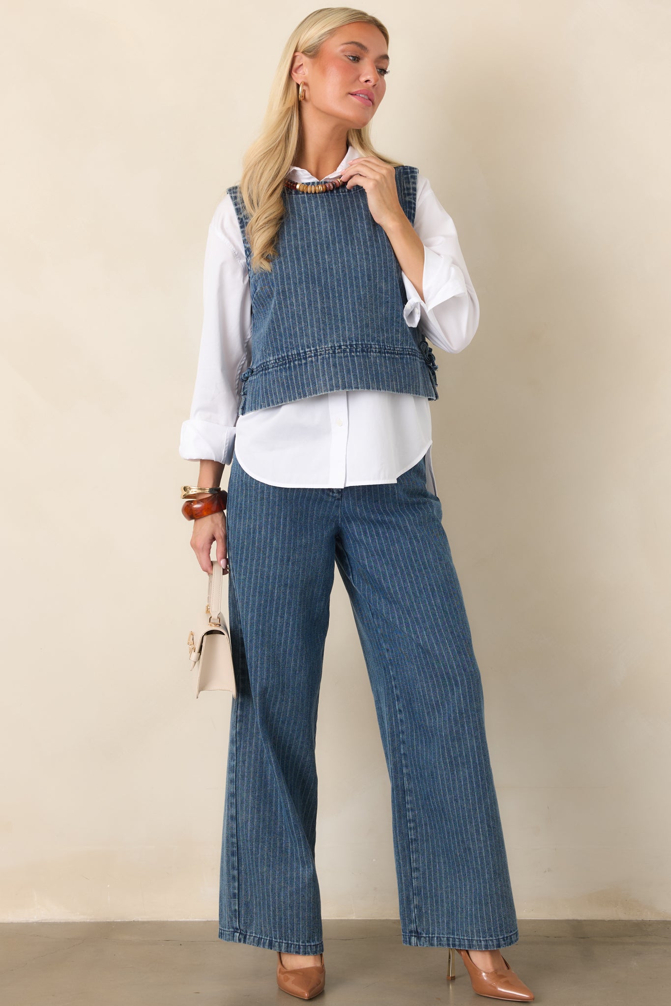 Indigo striped pants featuring a wide-leg silhouette, elastic waistband, adjustable drawstring tie, side pockets, and soft cotton-blend denim fabric.