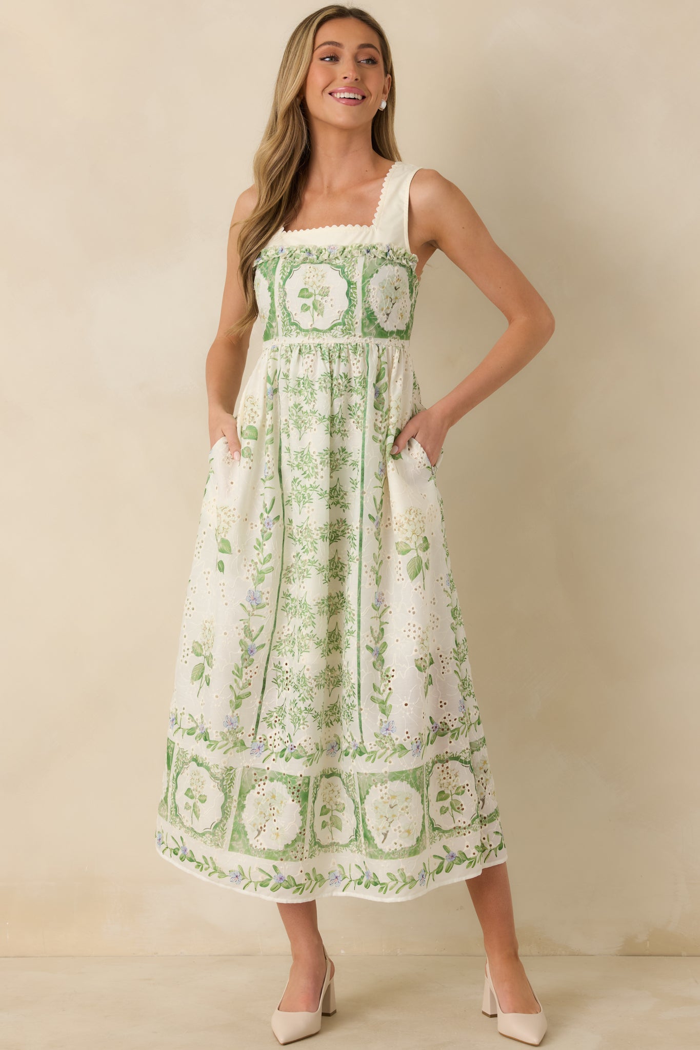 Ivory and green floral dress highlighting the clean square neckline, wide shoulder straps, and smooth transition into a lightweight woven skirt.