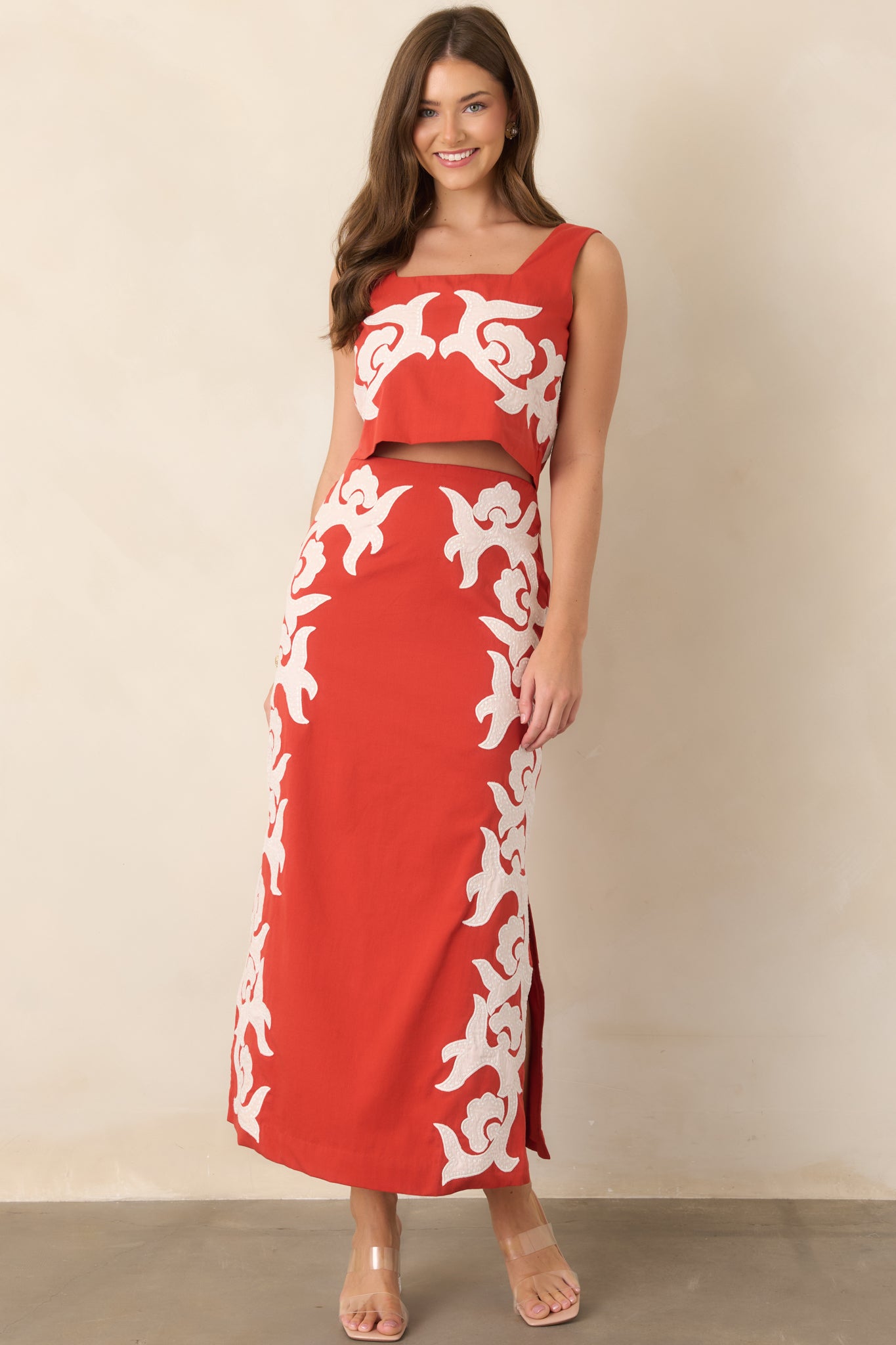 Polished column-style midi skirt with a high waist, soft cotton lining, decorative ivory appliqué, and clean side slits.