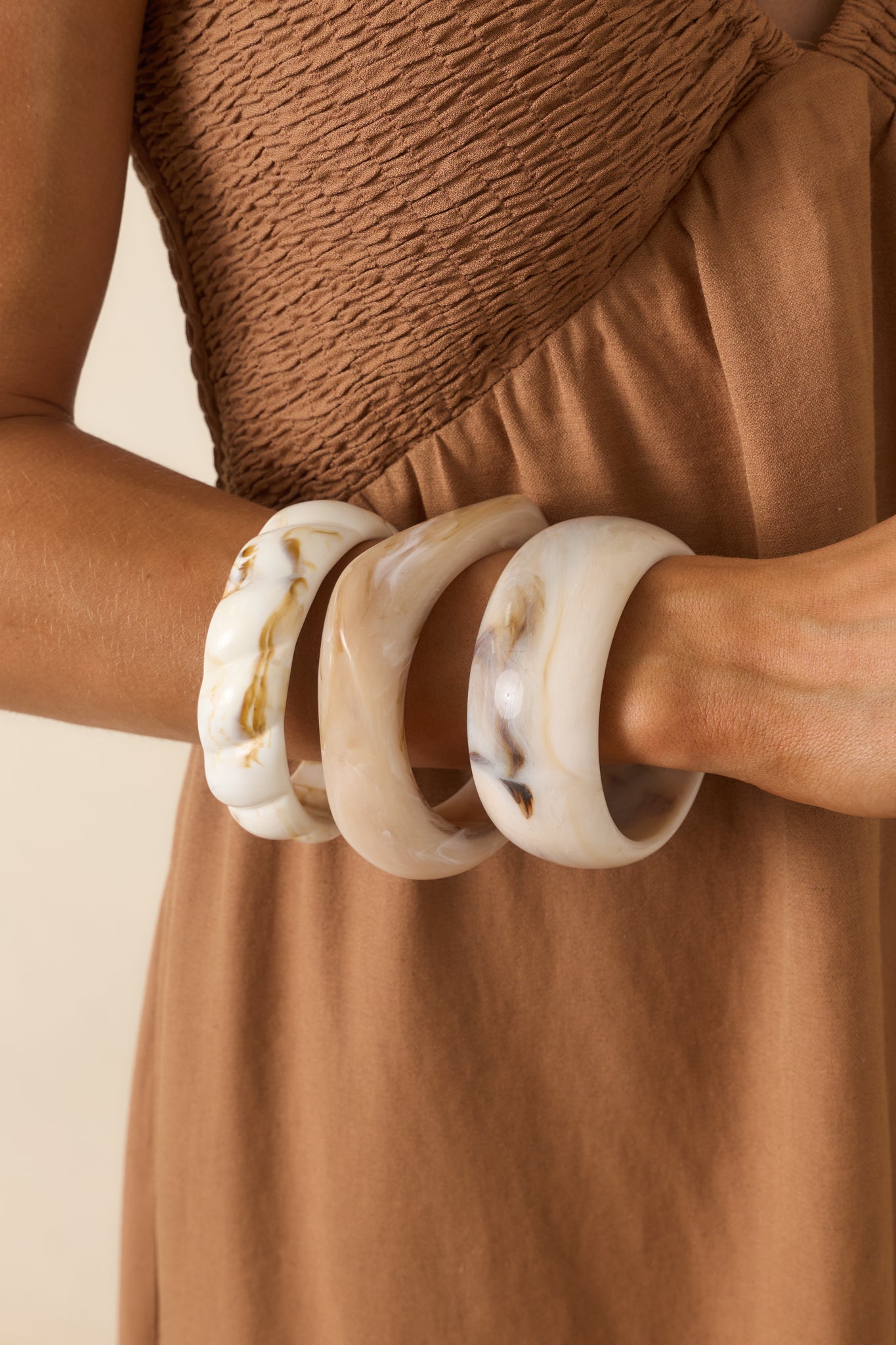 Lightweight bracelet set with coordinating ivory-toned bangles designed with varied marbled finishes and fluid shapes.