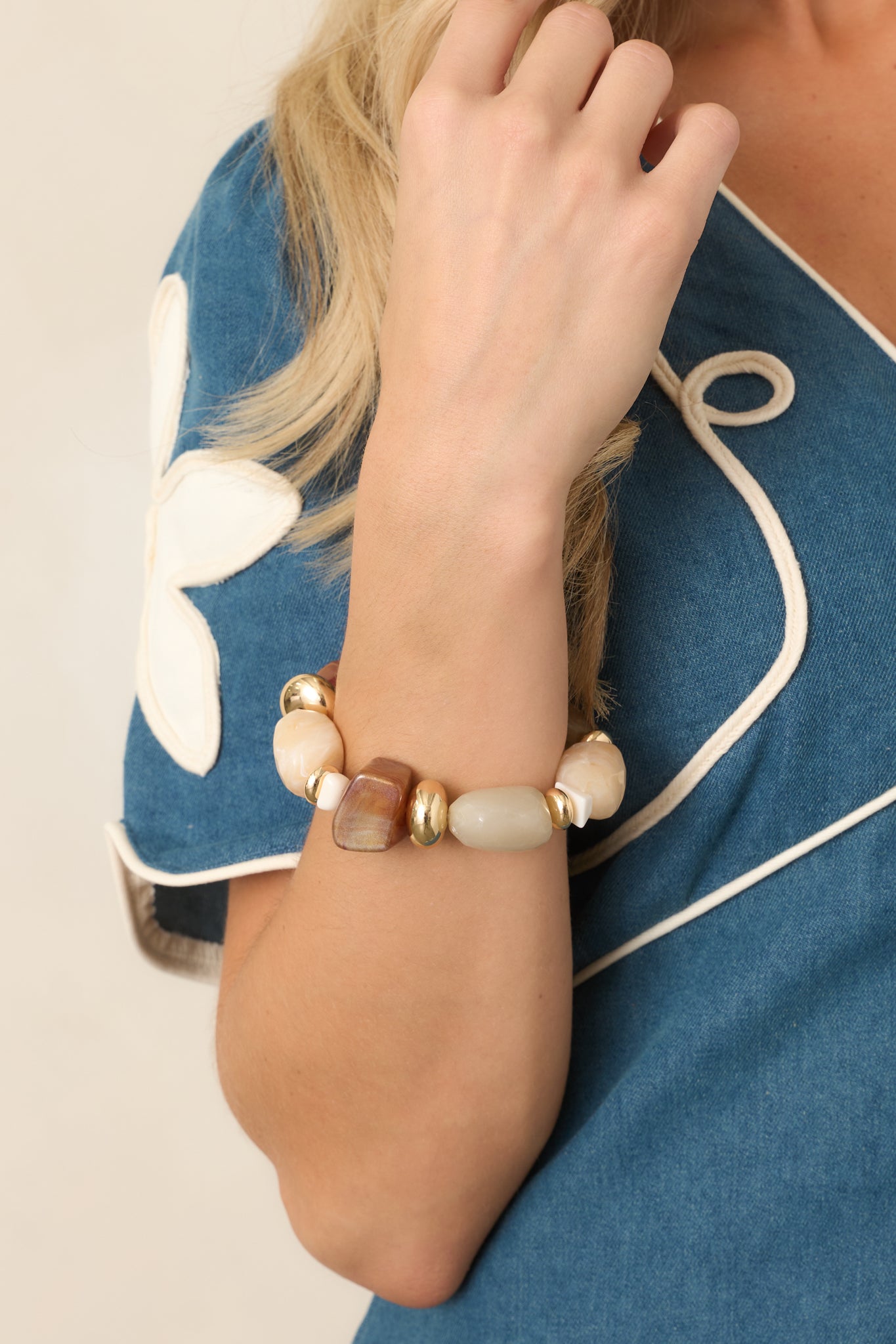 Mixed-bead bracelet featuring smooth and marbled beads in ivory, beige, taupe, caramel, and brown, accented with polished gold-tone details.