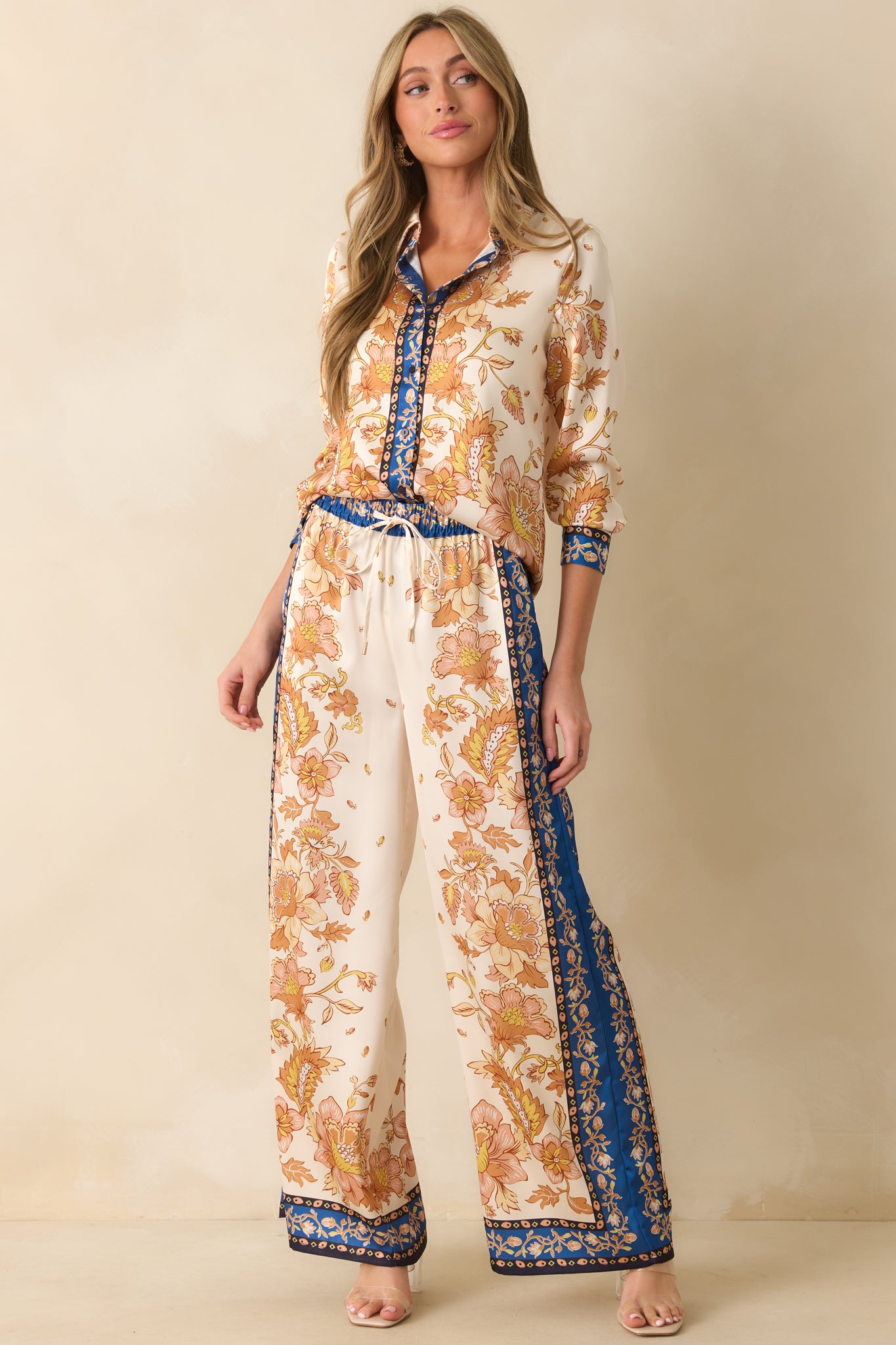 Ivory blouse with flowing silhouette, floral scarf-style print, and subtle navy trim along the edges.