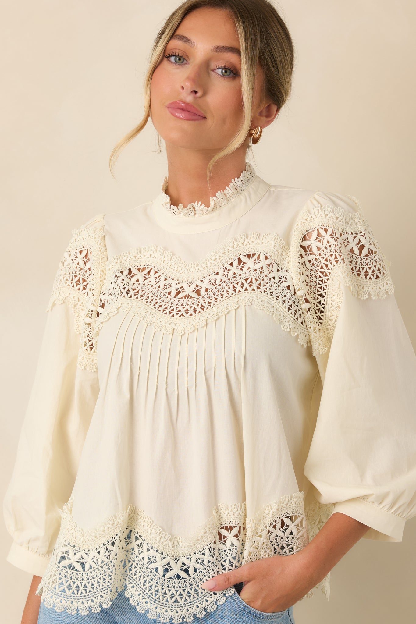 The front of this ivory blouse highlights the lace-trimmed neckline and scalloped openwork yoke.