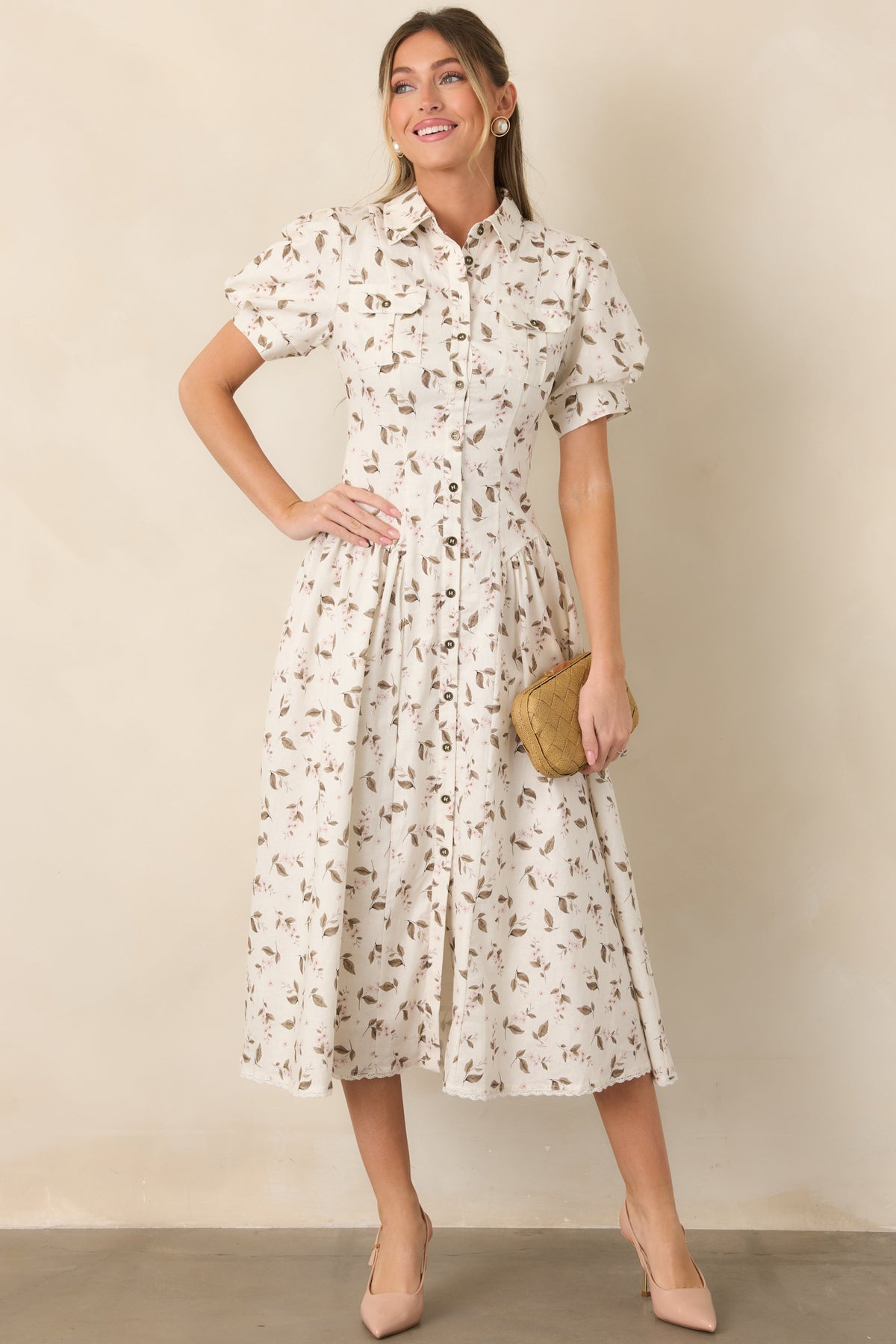 Delicate blush florals and olive-taupe leaves scatter across the ivory dress, complemented by a shaped waist and flap chest pockets.