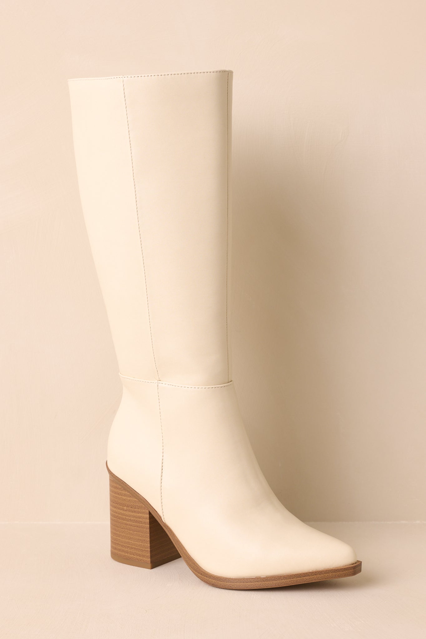 A cropped front view of the ivory boots with the structured shaft and sleek pointed toe.