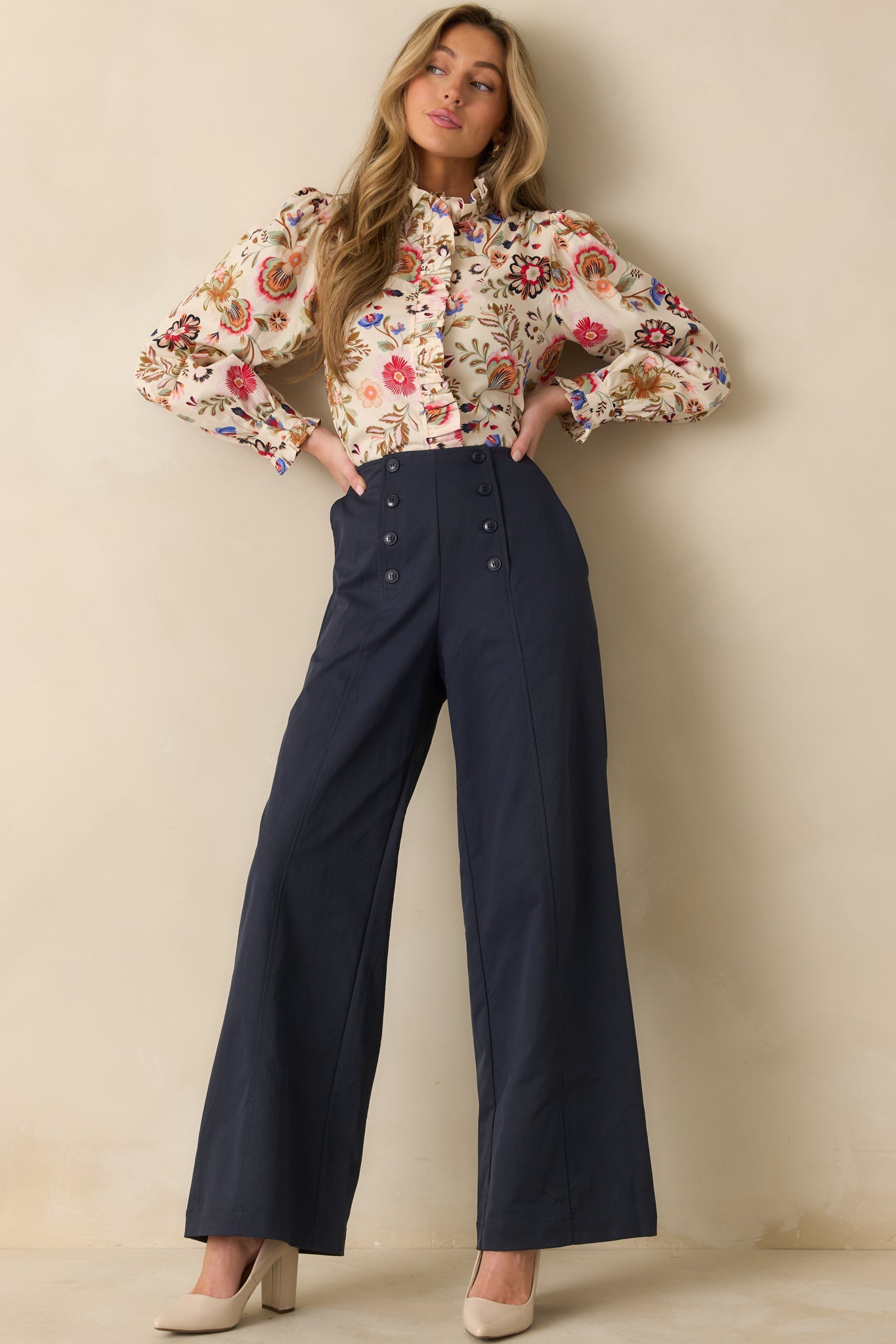 Ivory button-up top with ruffled mock neckline, long puff sleeves, and delicate floral print for a feminine look.