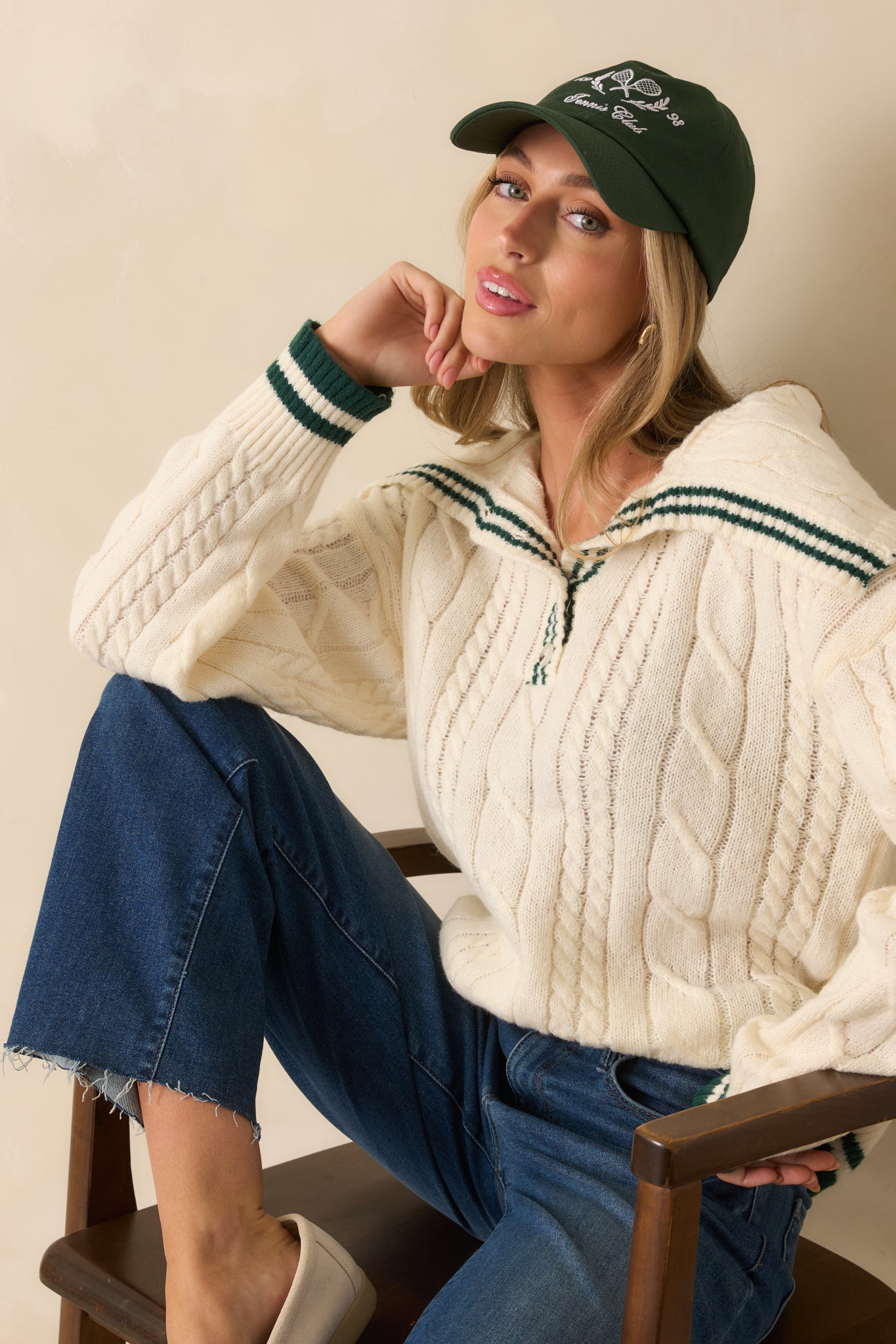 Ivory cable knit sweater with a relaxed Johnny collar, quarter button front, and hunter green striped contrast trim.