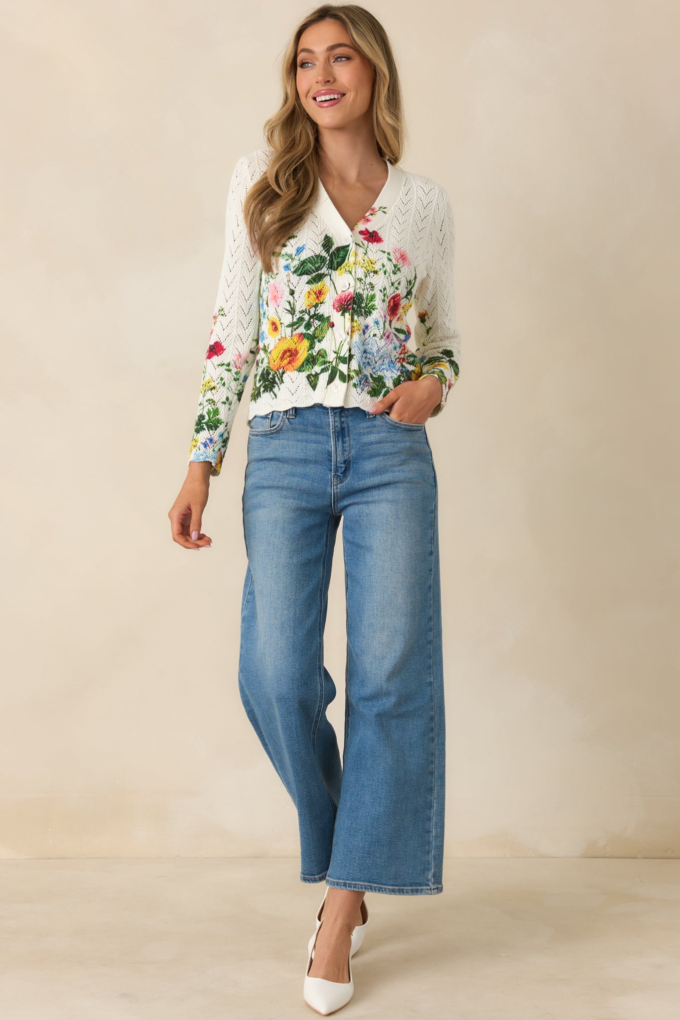 Ivory long sleeve cardigan with multicolor floral print, lightweight cotton pointelle knit, and V-neckline with button-front closure.