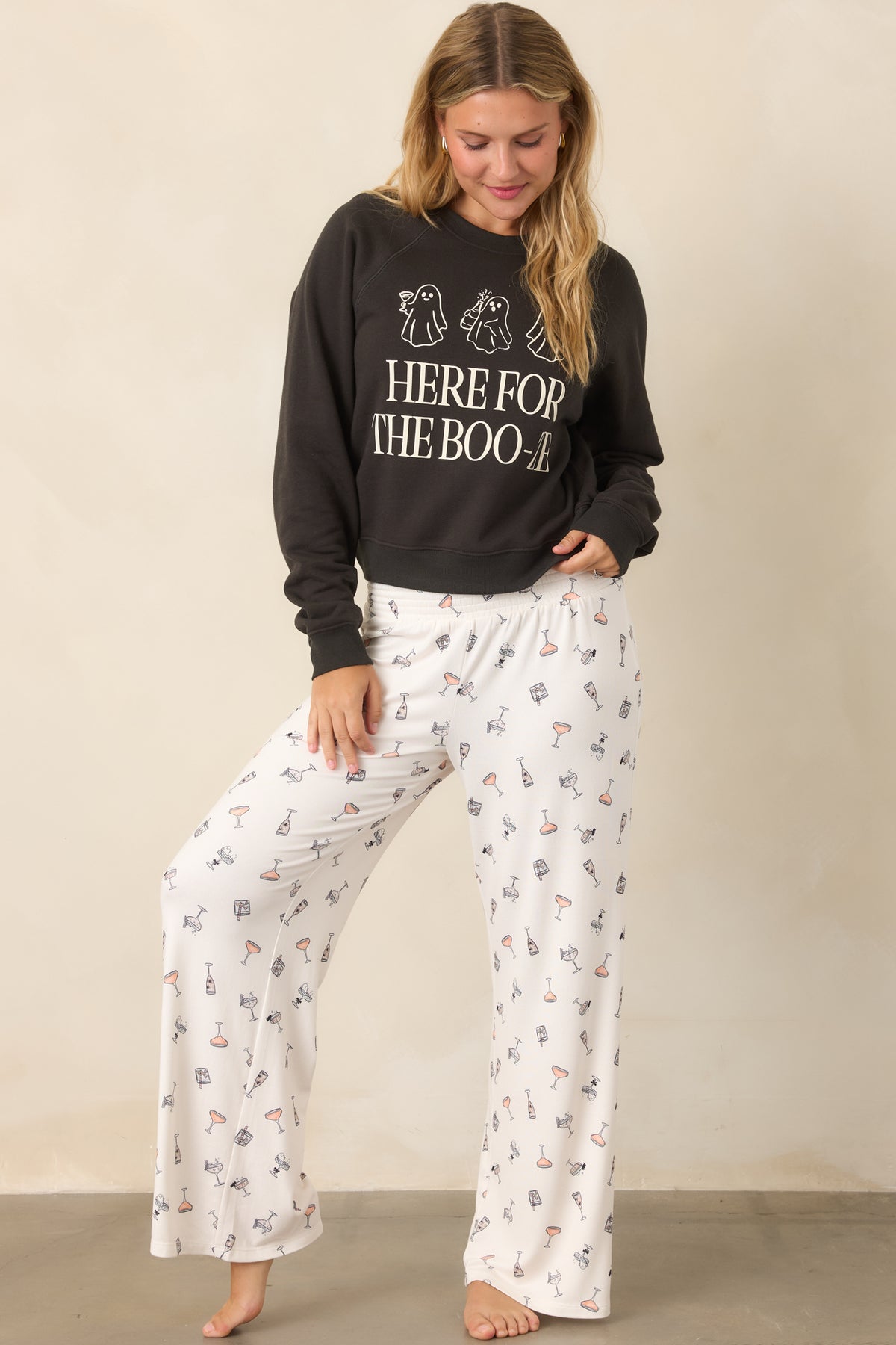Ivory silky stretch jersey pants featuring a playful cocktail print with tiny spooky details, a wide smocked waistband, and relaxed wide legs.