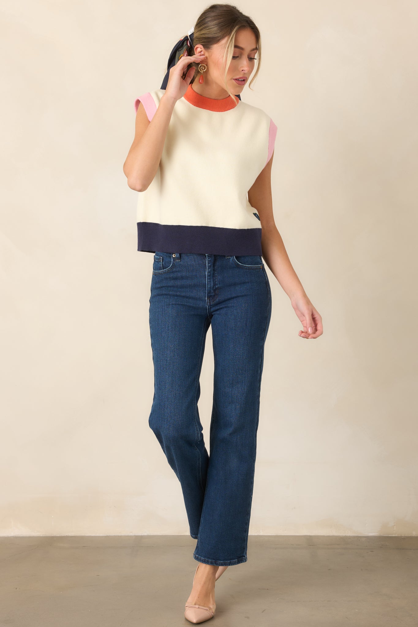 Sleeveless ivory top accented with colorful contrast trims, including an orange neckline, soft pink armholes, and a structured navy ribbed hem with a heart-shaped FRNCH patch.