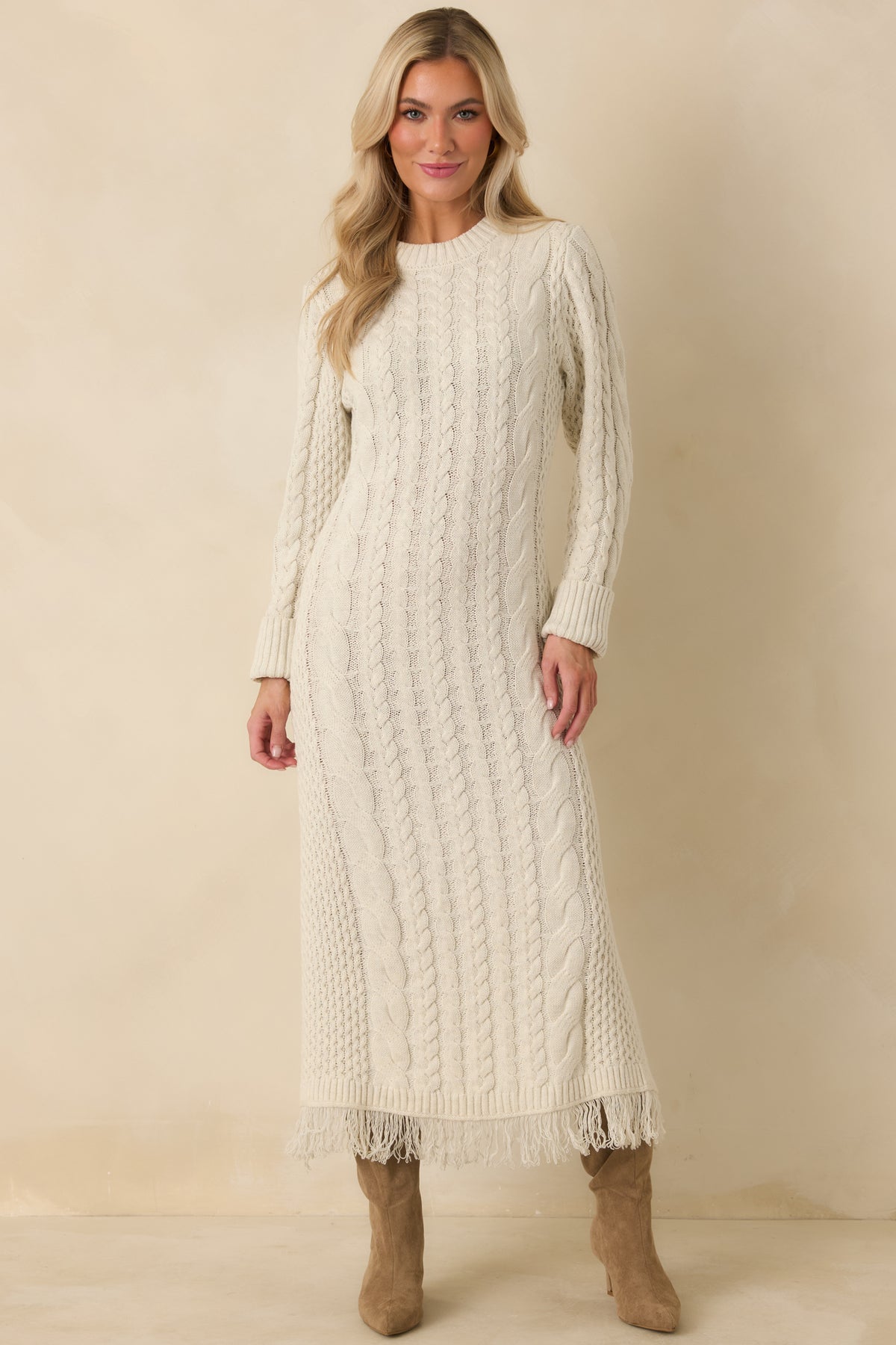 Ivory cotton-blend maxi dress with intricate vertical cable knit detailing and delicate fringe along the hem.