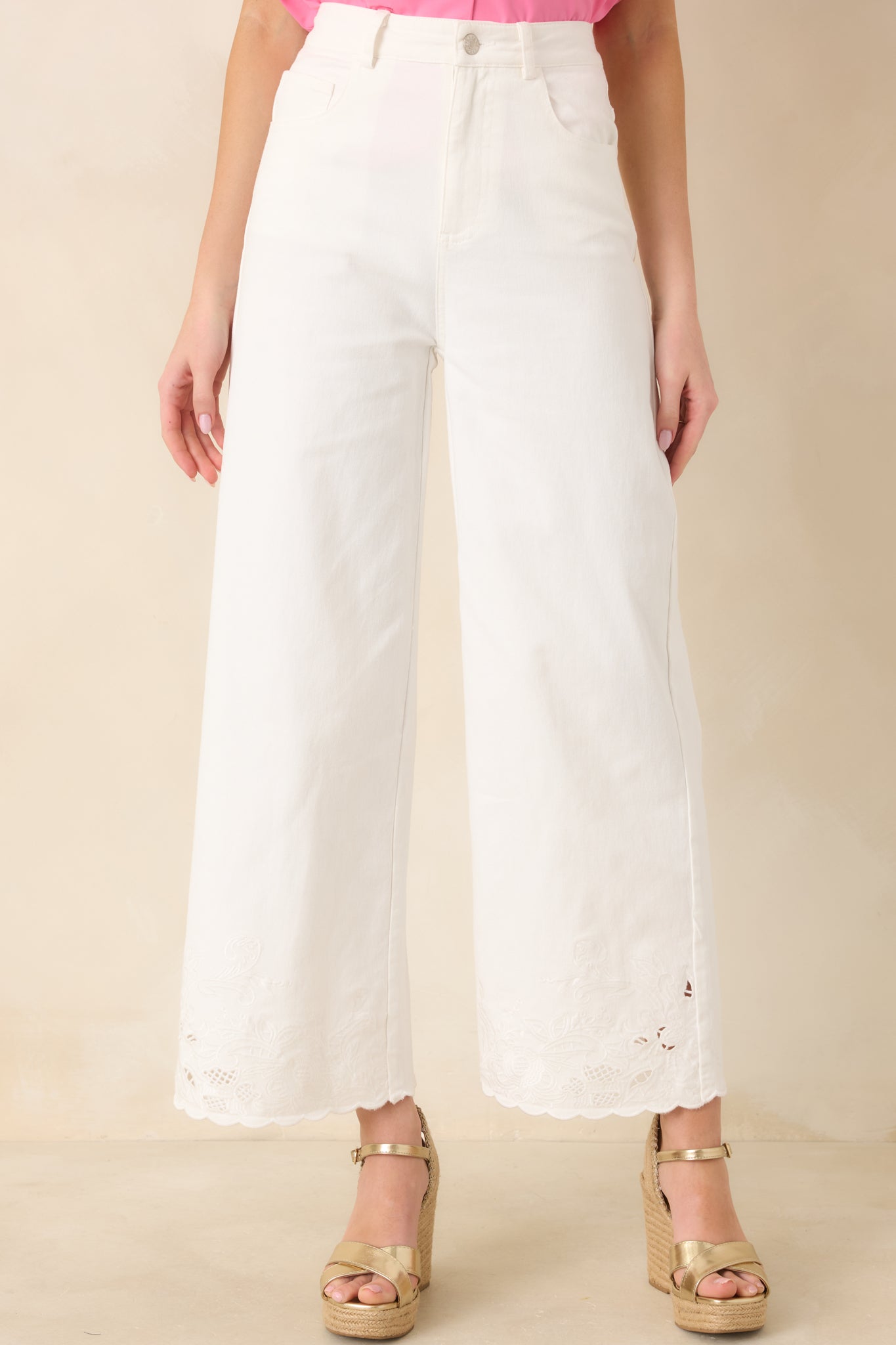Ivory cotton pants highlighting the high-rise waistband and smooth front closure with tailored structure.