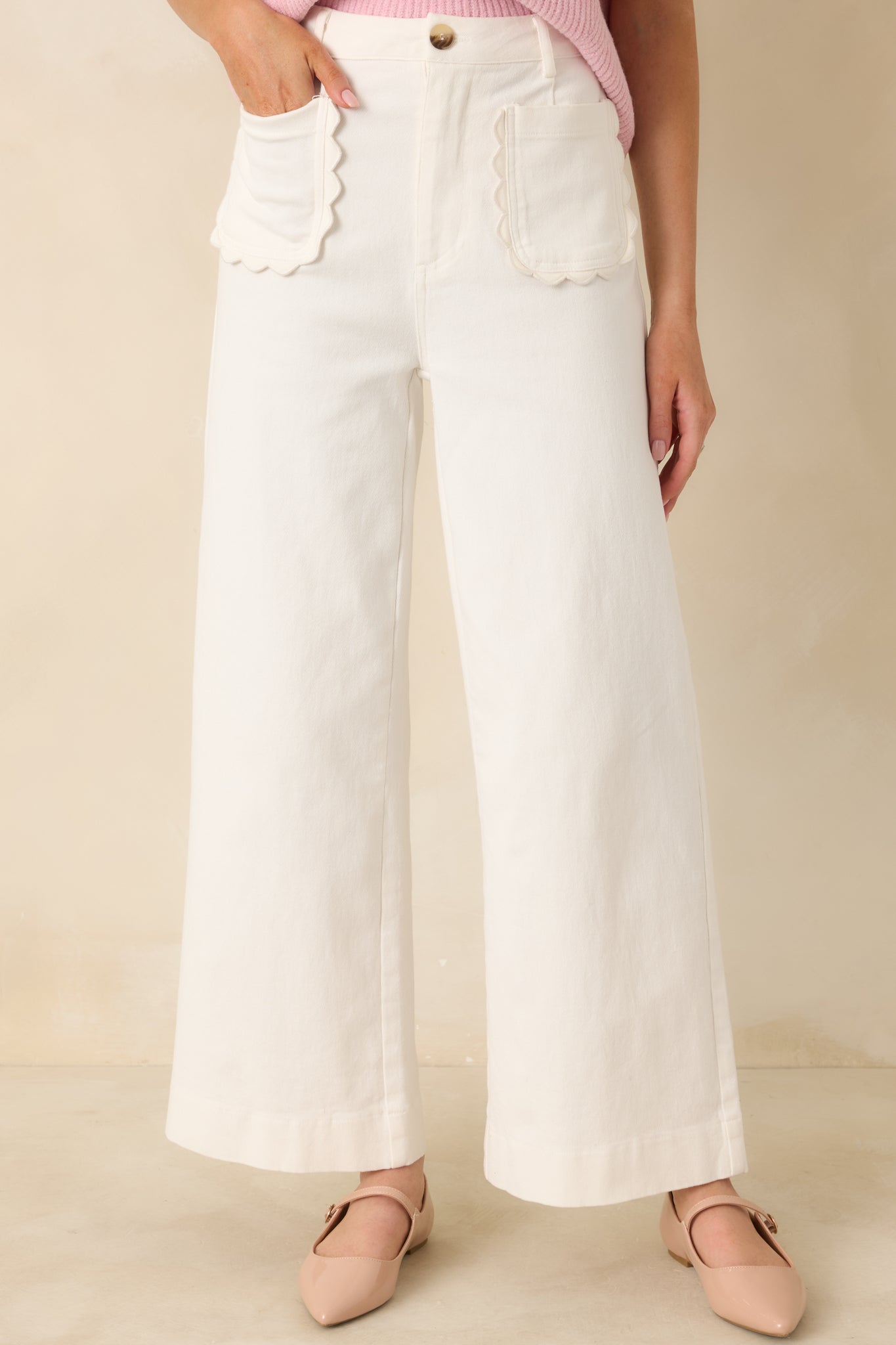 Ivory cotton pants shown from the front highlighting the wide leg fit and belt loops.