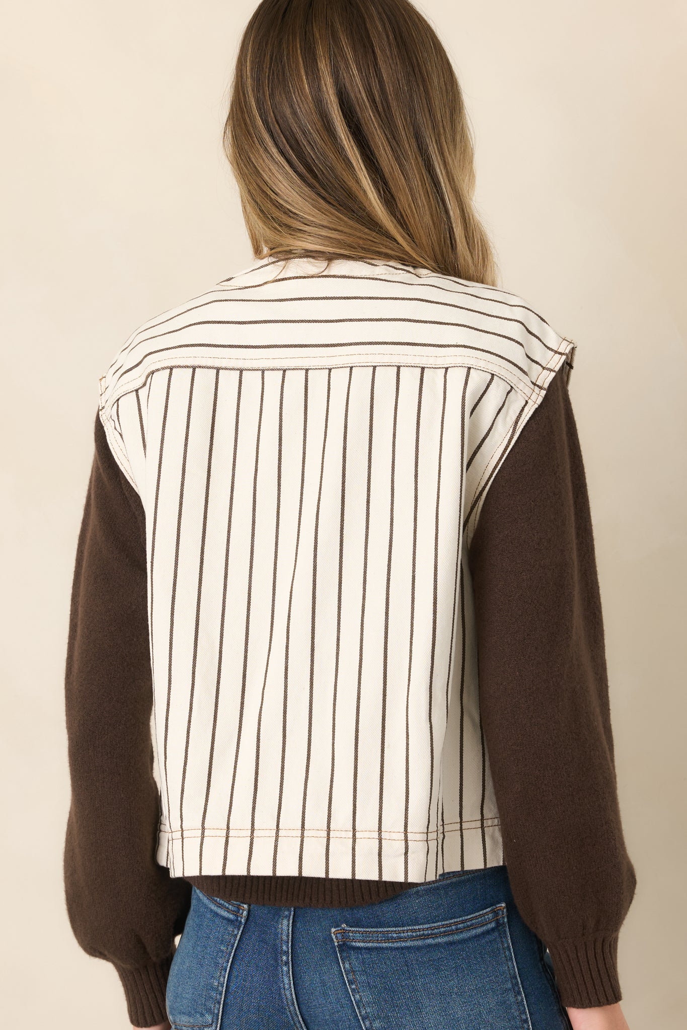 Rear view of the ivory cotton vest showcasing the horizontal striped yoke, vertical brown pinstripes, and relaxed boxy fit.