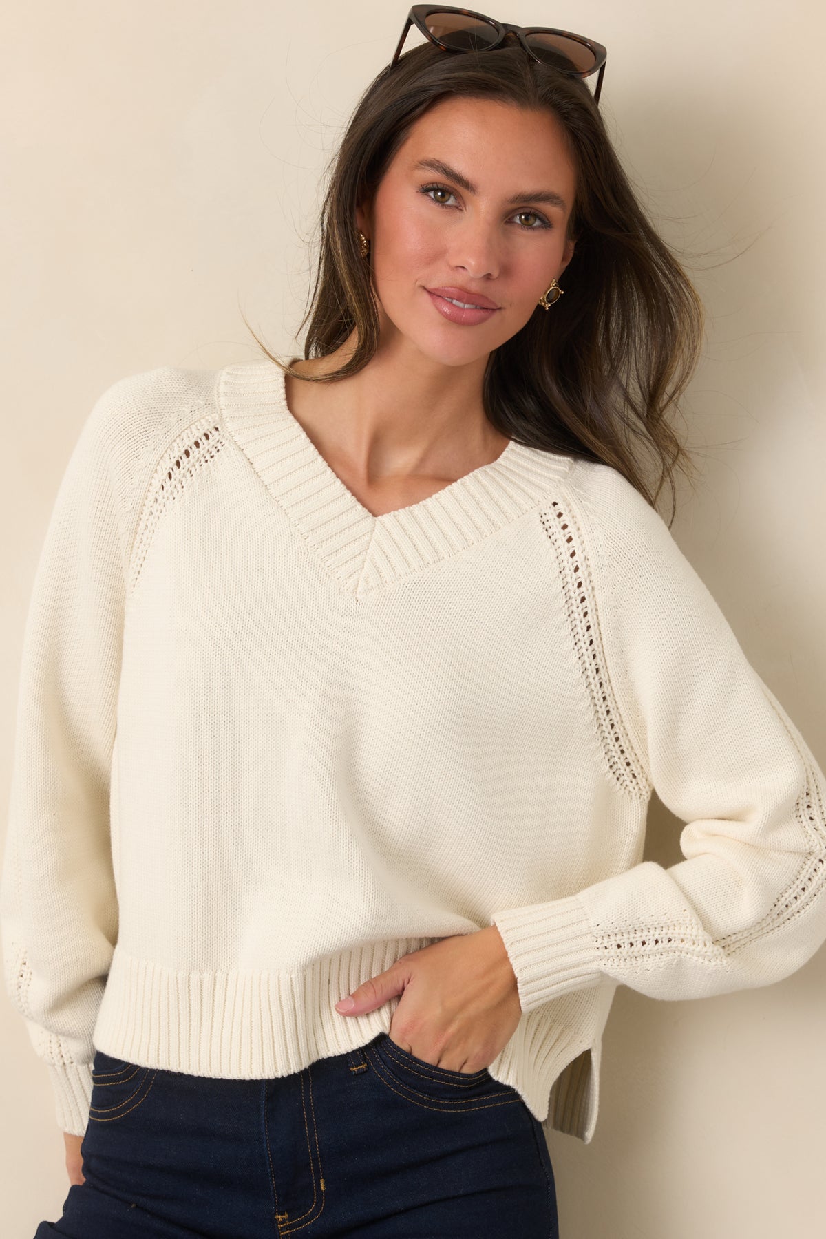 Ribbed V-neckline adds definition to the ivory cotton top, complemented by delicate pointelle stitching along the shoulder seams.