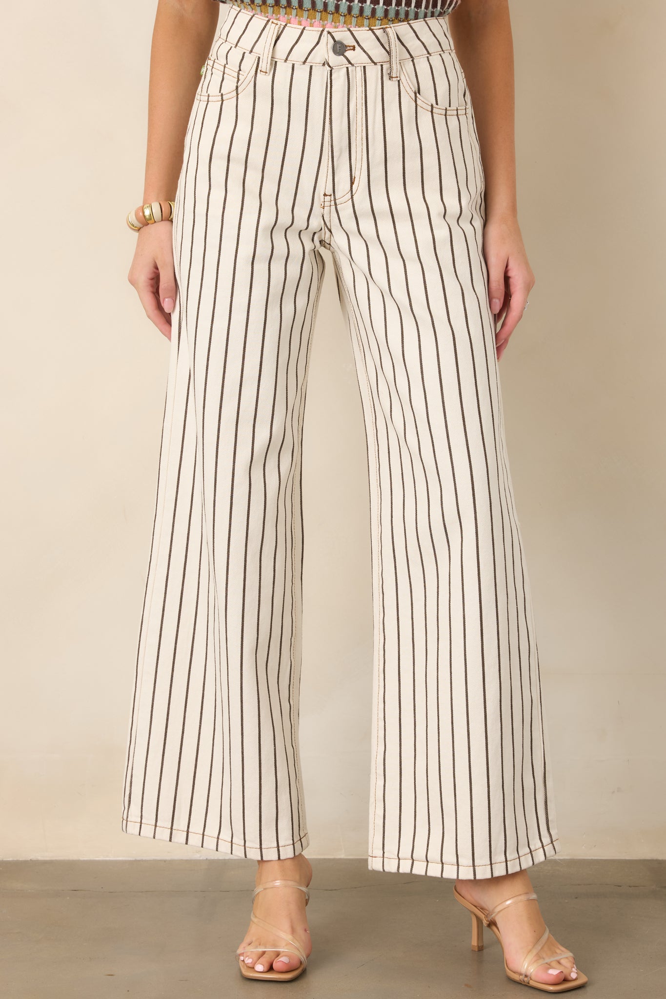 Ivory cotton pants highlighting the clean vertical brown stripe pattern, structured denim construction, and relaxed wide-leg silhouette.