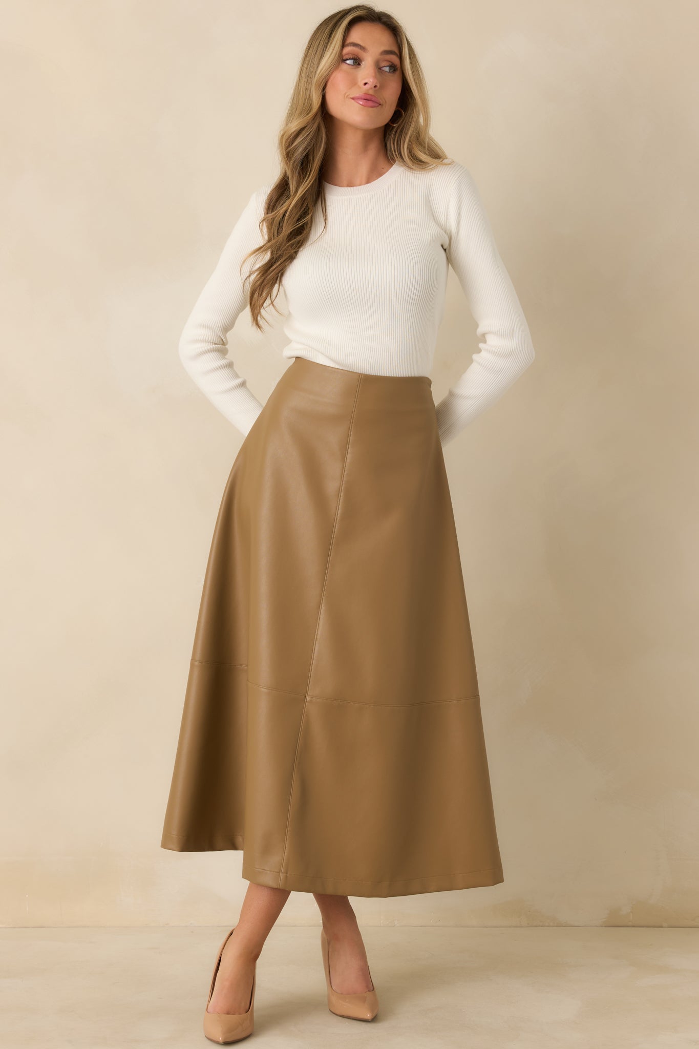 Ivory ribbed knit top featuring sleek long sleeves, a close-fitting shape, and a simple crew neck.