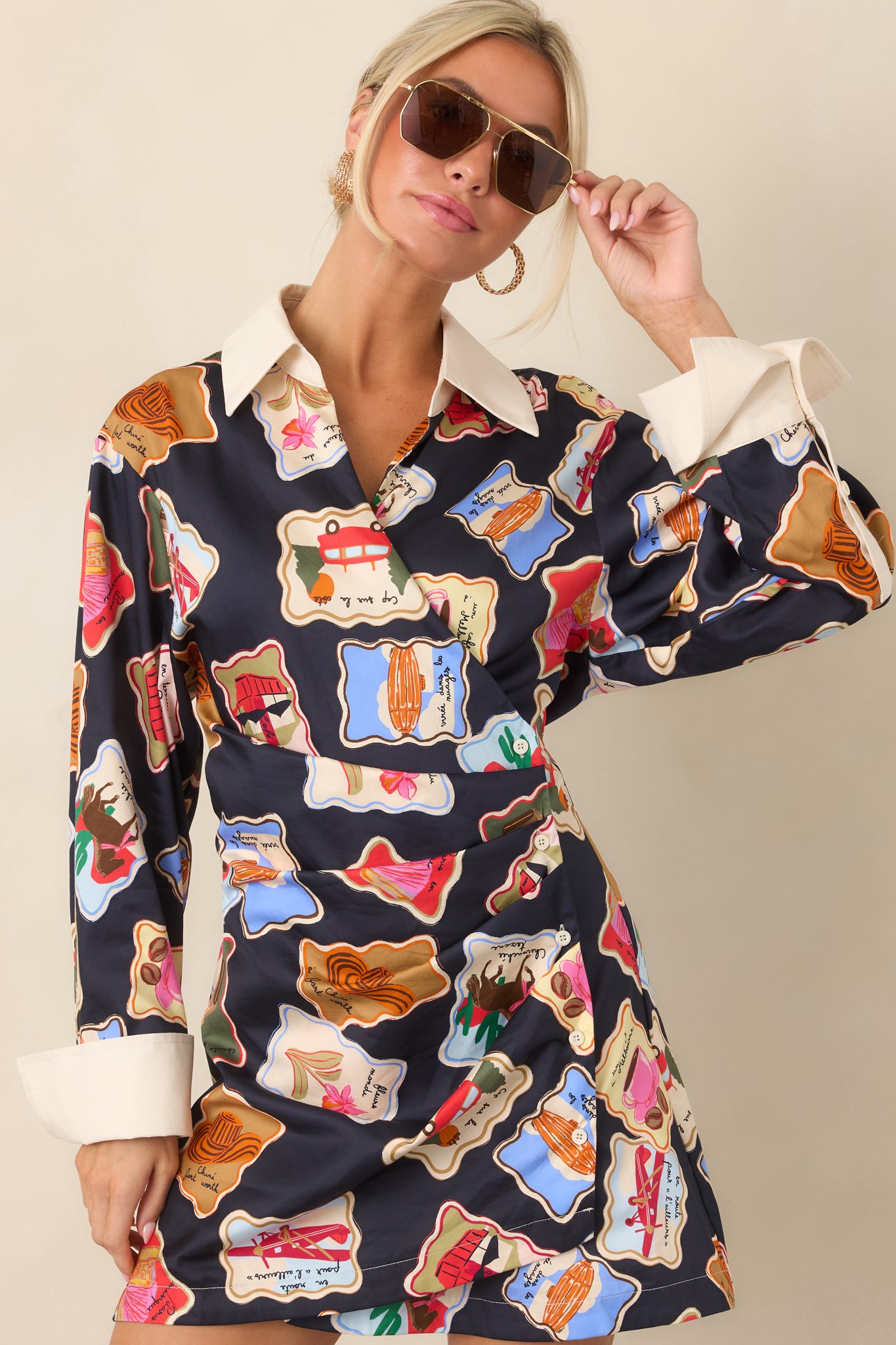 Upper portion of the printed mini dress showcasing its ivory contrast cuffs, long sleeves, and colorful illustrated motifs.