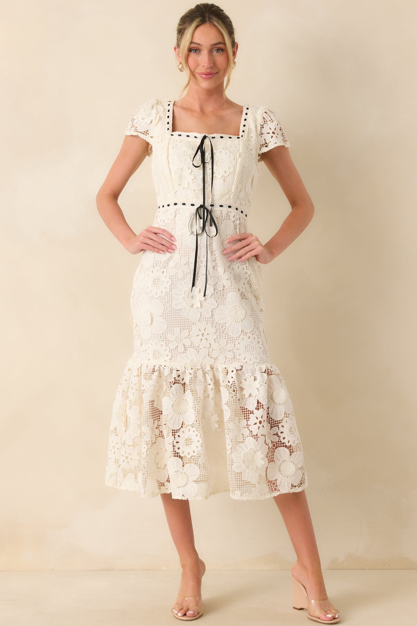 A front view of the ivory dress with a square neckline, embroidered short sleeves, and fitted mermaid silhouette.
