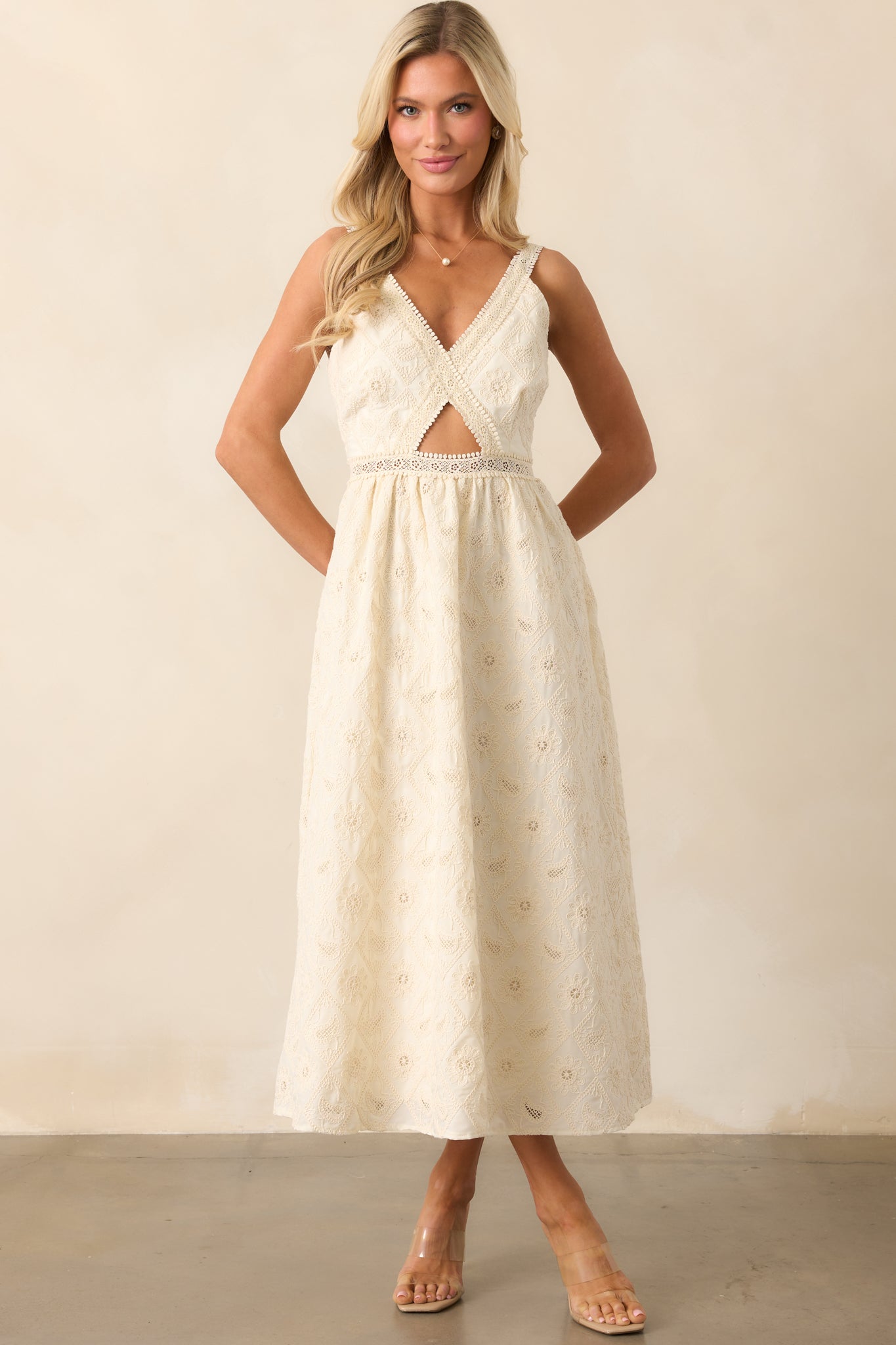 The ivory dress features lace embroidery throughout, a chic v-neckline, and a cutout in the bodice, with adjustable straps to ensure a comfortable and stylish look.