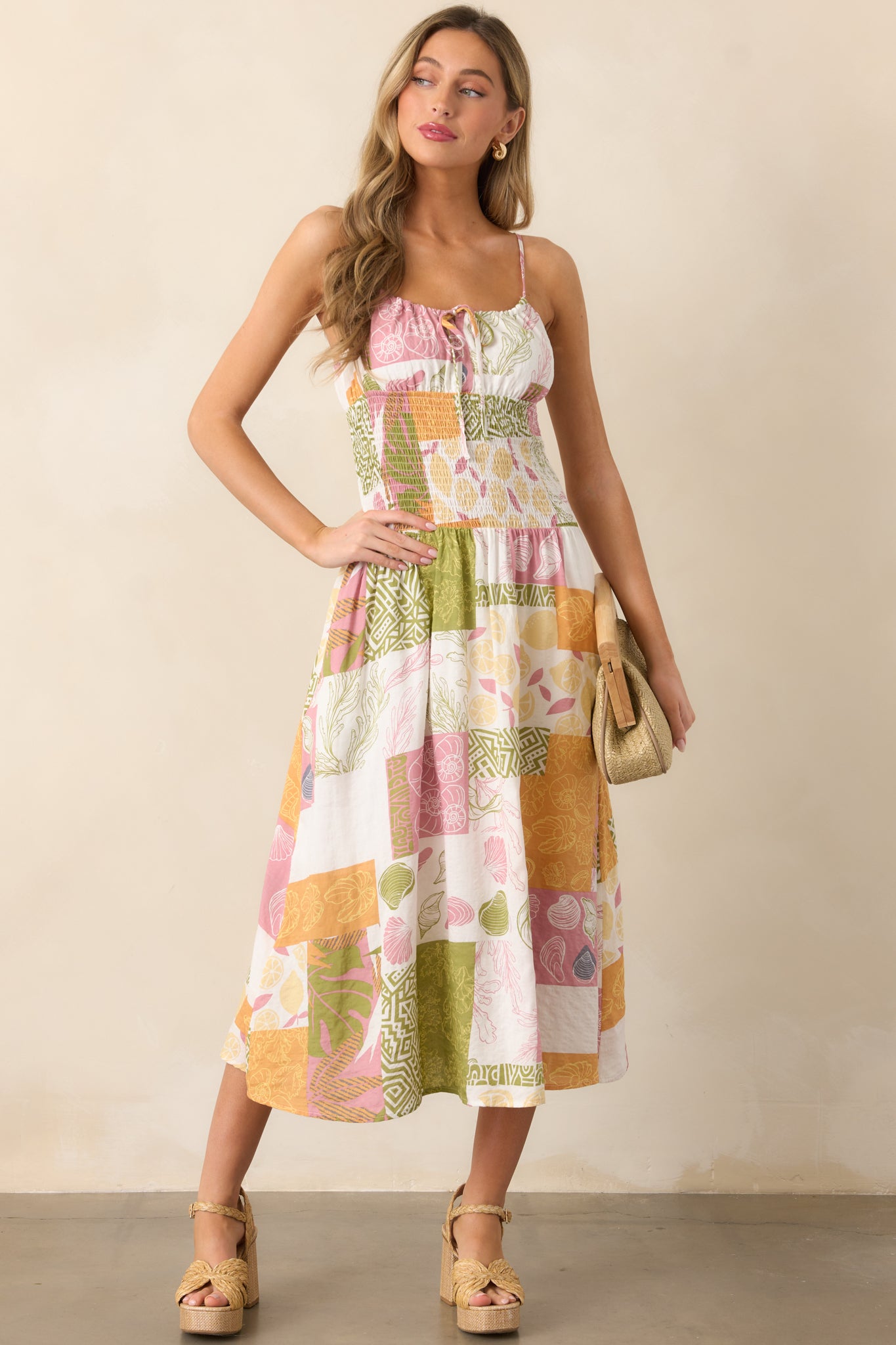 Elegant ivory dress with a smocked waistband and tropical patchwork design, perfect for a breezy, warm-weather style.