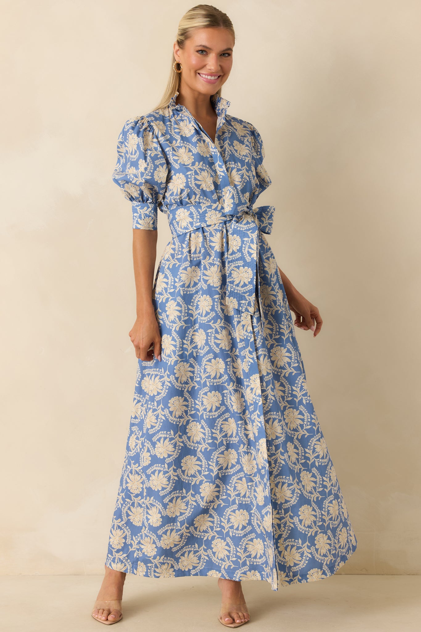 Ivory and dusty blue floral maxi dress featuring a ruffled neckline, self-tie waist, full skirt, and lightweight cotton fabric.