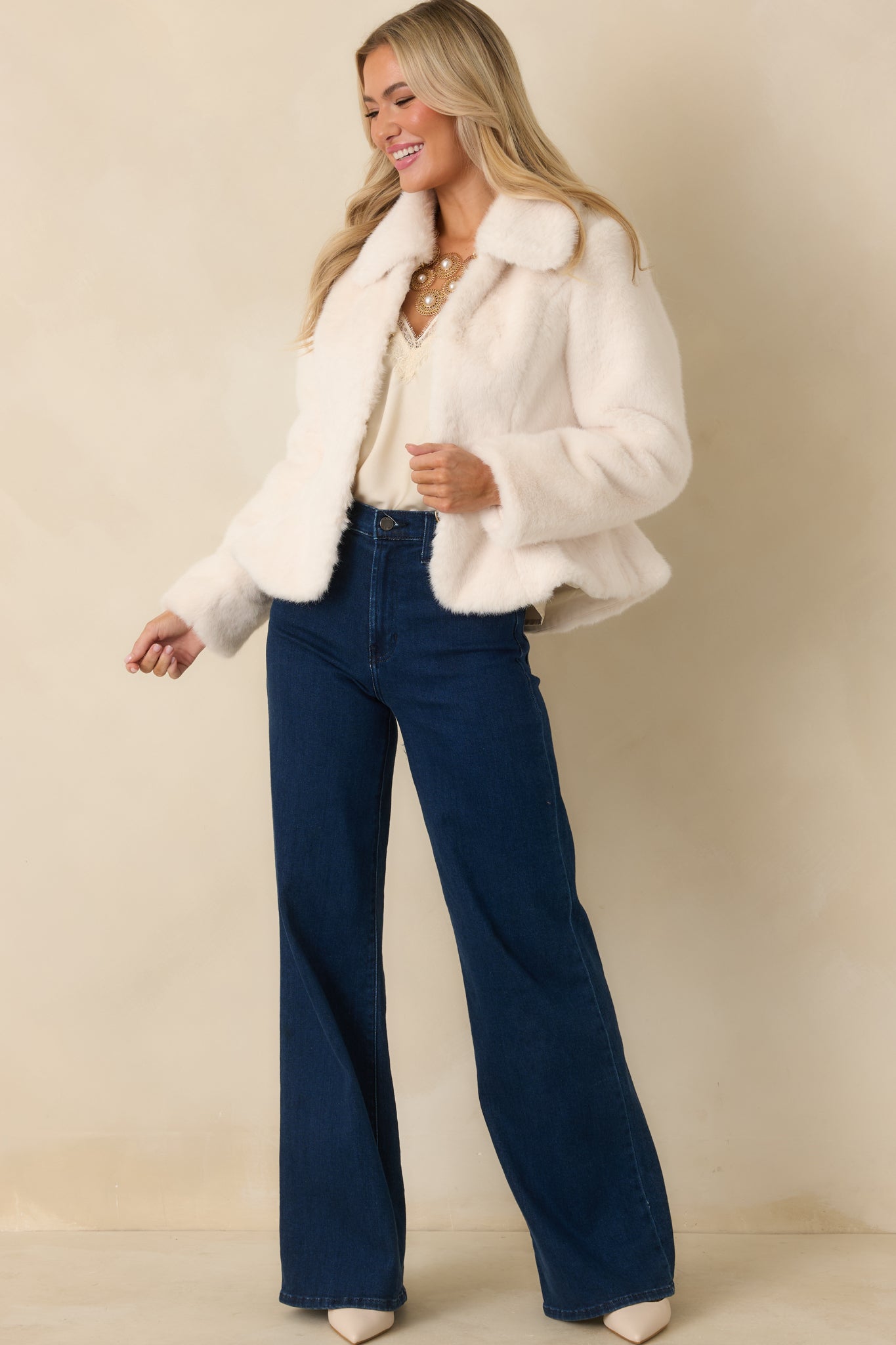 Ivory faux fur coat featuring a refined collar and tailored fit that creates a sleek, warm outer layer.