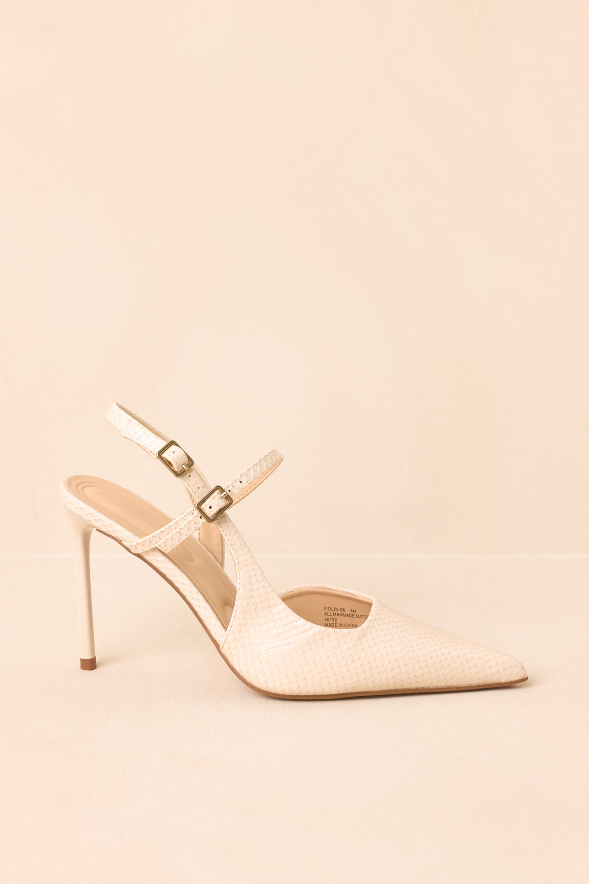 Ivory faux snakeskin heels feature a pointed toe, slim stiletto heel, and double-strap design with petite buckle closures.