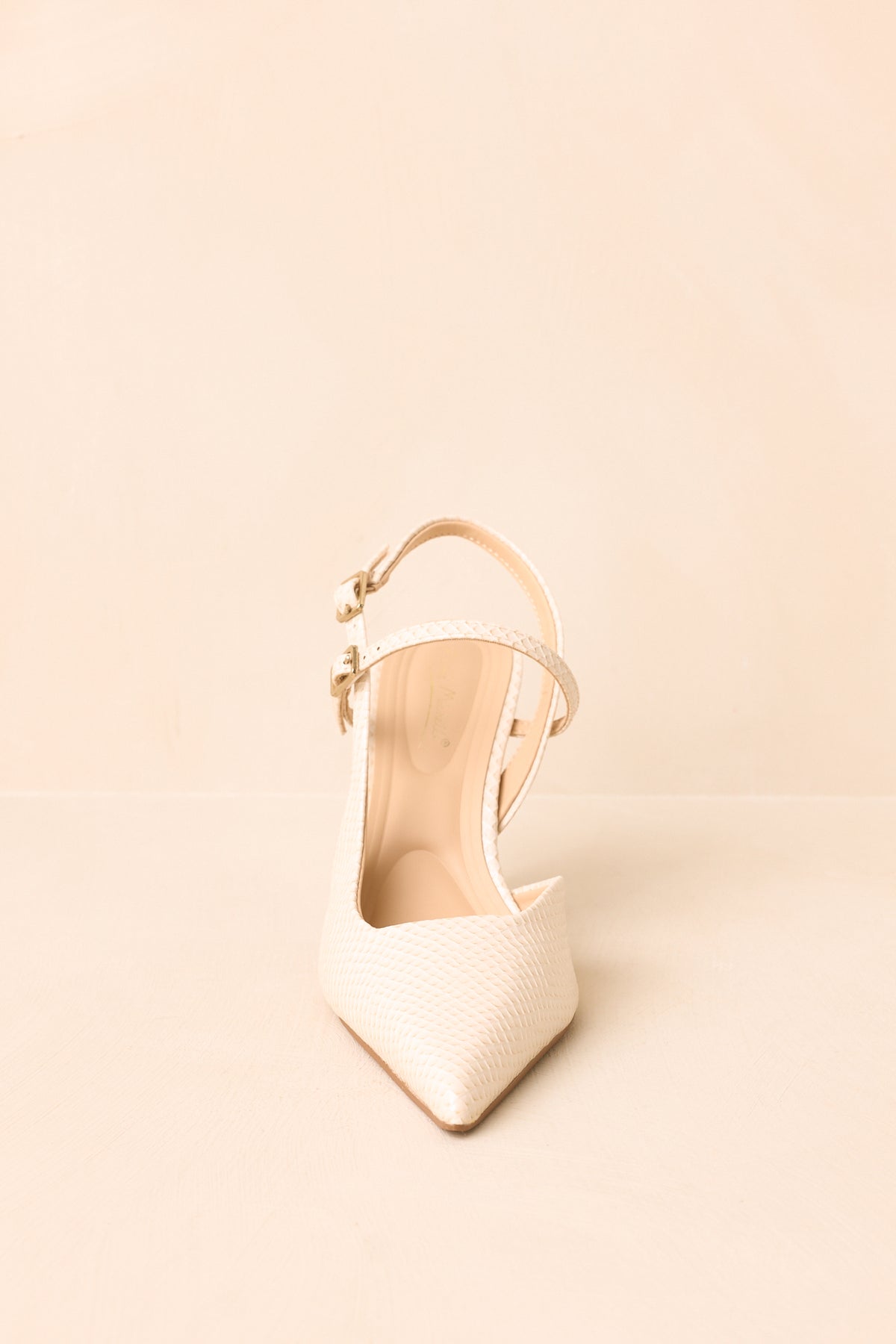 Close-up highlights the ivory faux snakeskin texture, pointed toe, double straps, and petite buckle closures.