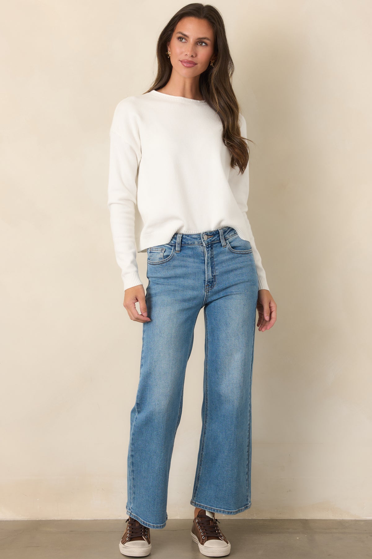 Ivory fine-knit top with a relaxed silhouette, dropped shoulders, long sleeves, and crew neckline.