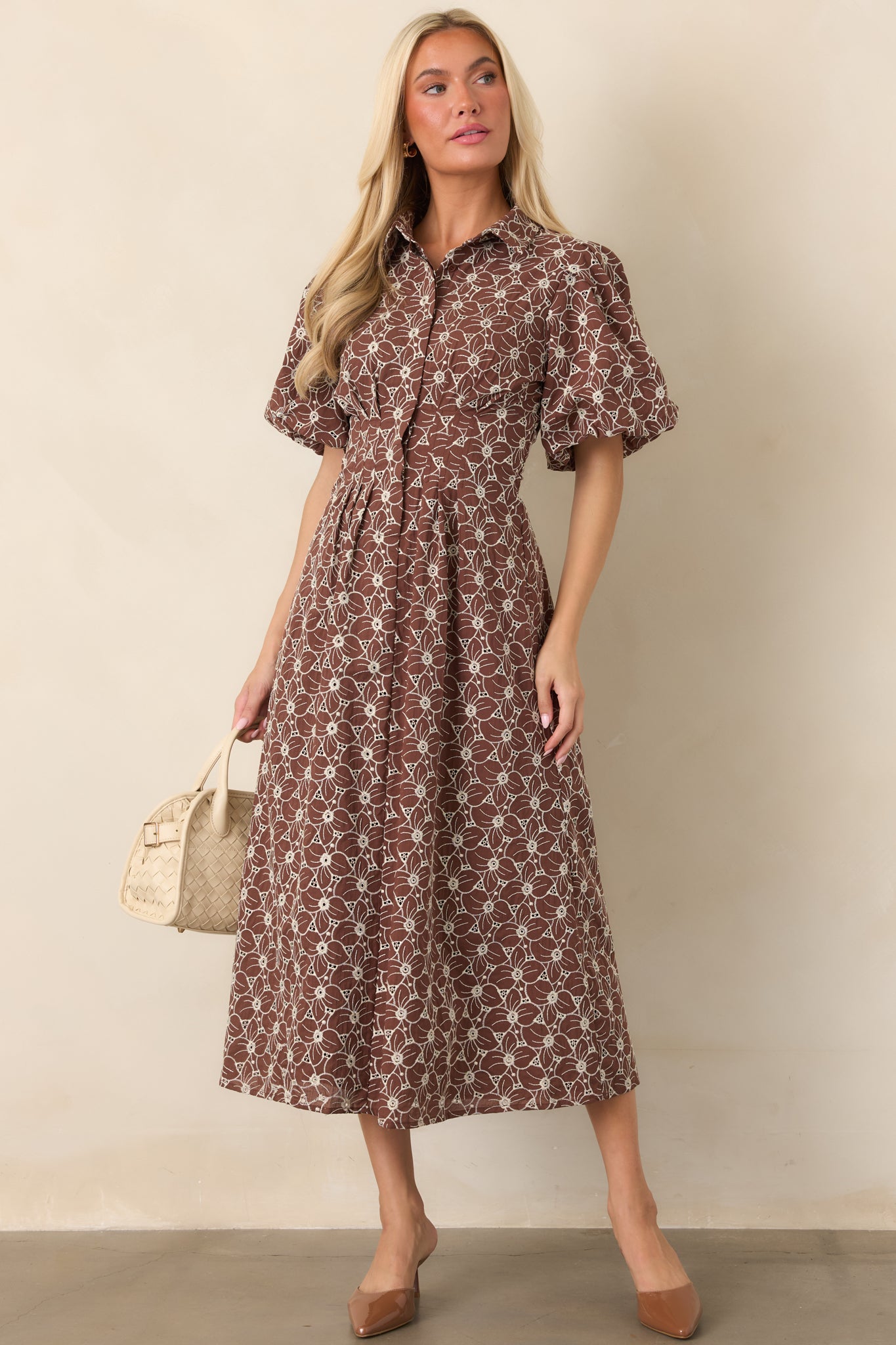 Feminine eyelet midi dress with an embroidered floral pattern, short puff sleeves, defined waist, and softly gathered full-length skirt.
