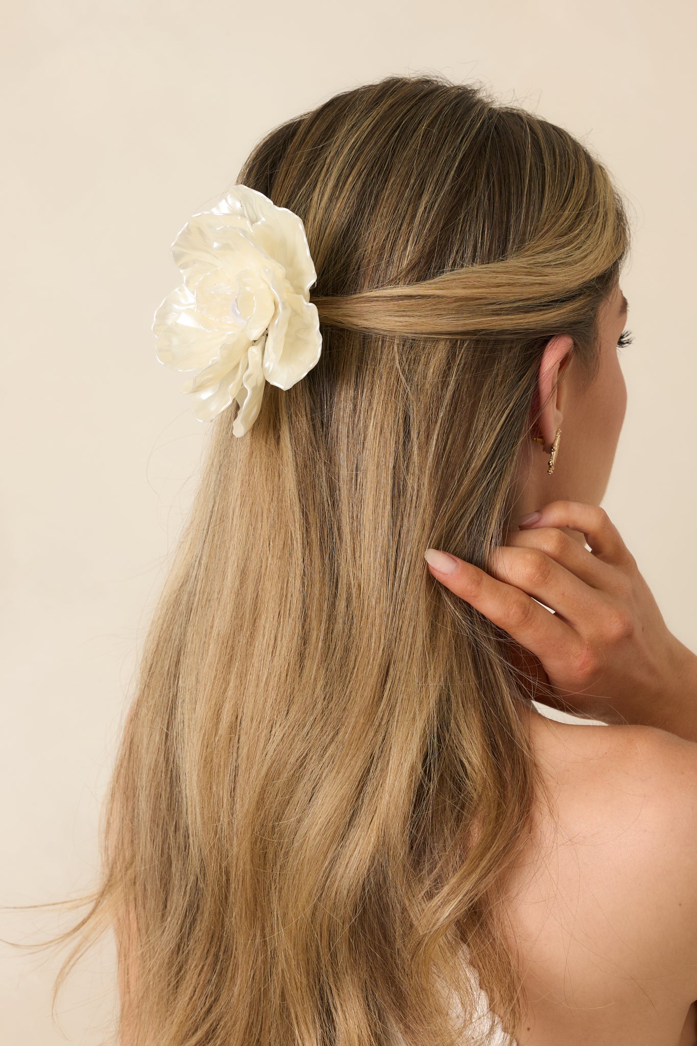 Ivory floral hair clip featuring layered petal-shaped detailing with a glossy, pearlescent finish and a faux pearl center.