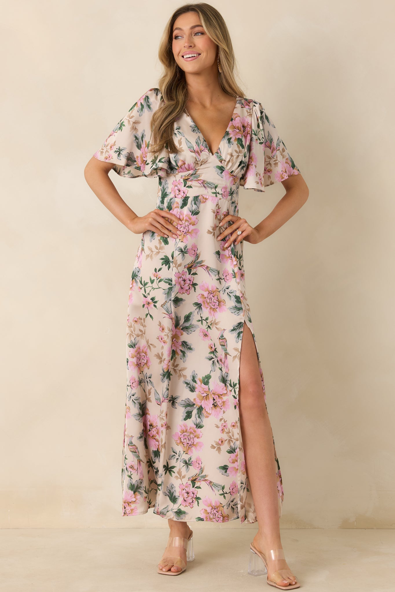 Ivory floral maxi dress with deep neckline and elongated flowing design.
