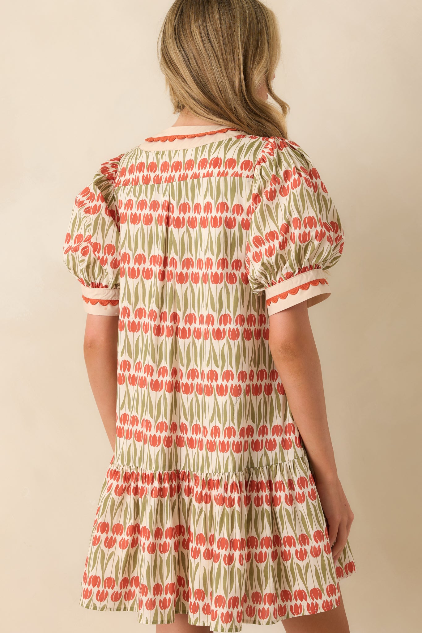 Rear view of the ivory floral mini dress with puff sleeves and clean straight hemline.