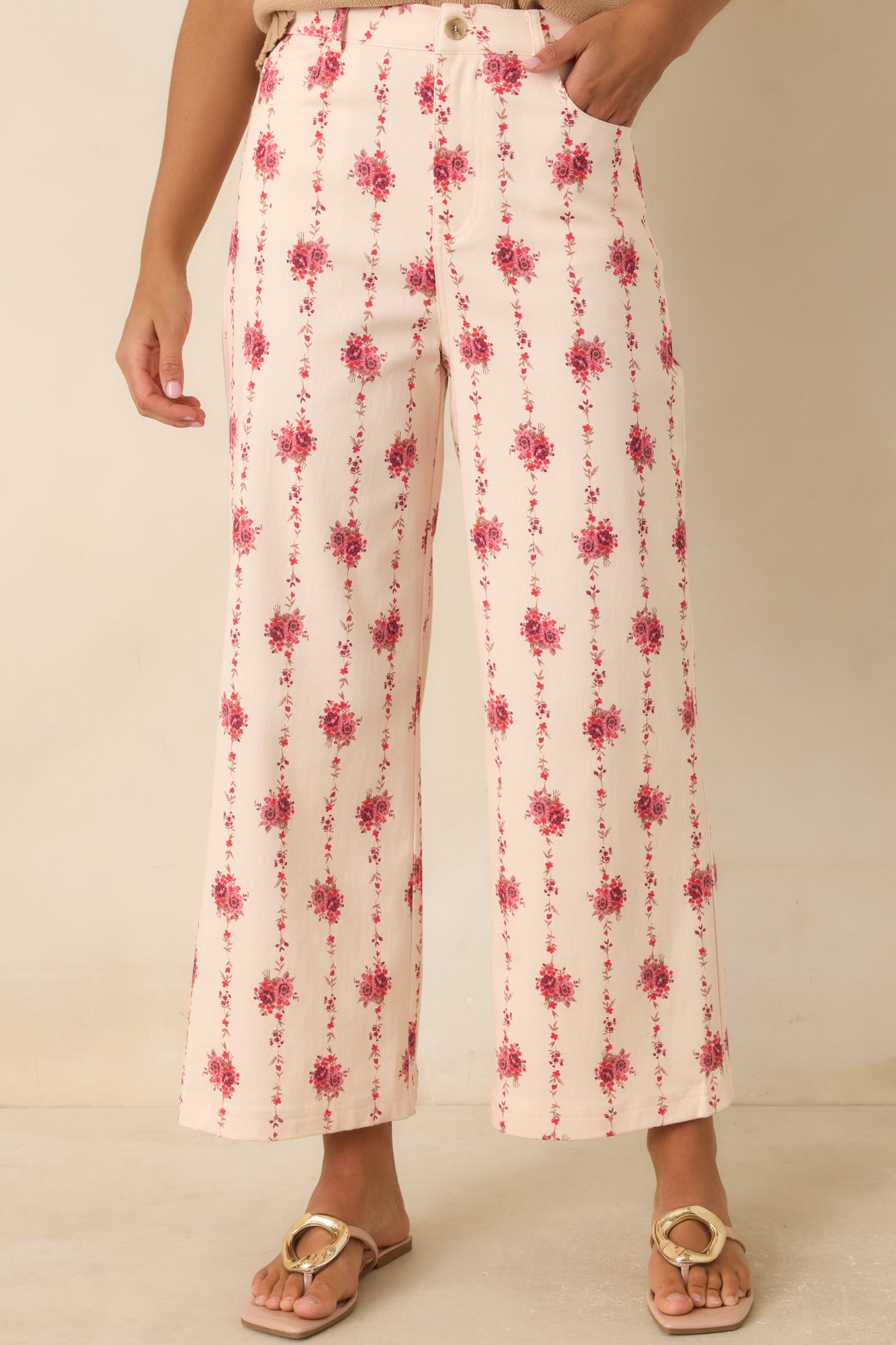 Ivory floral pants showcasing the vertical botanical pattern, smooth waistband, and refined button-front design.